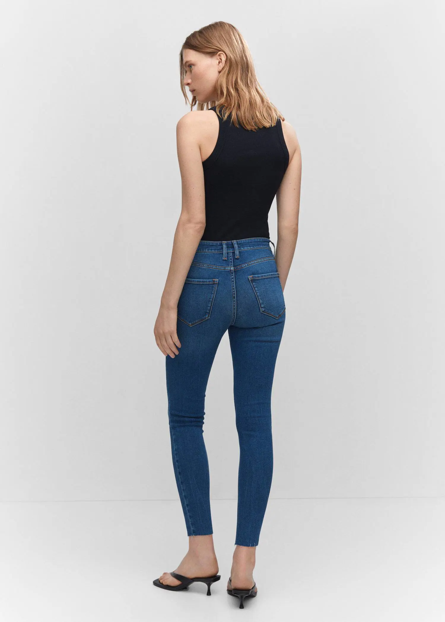 Mango Skinny cropped jeans. a woman is standing in front of a wall. 