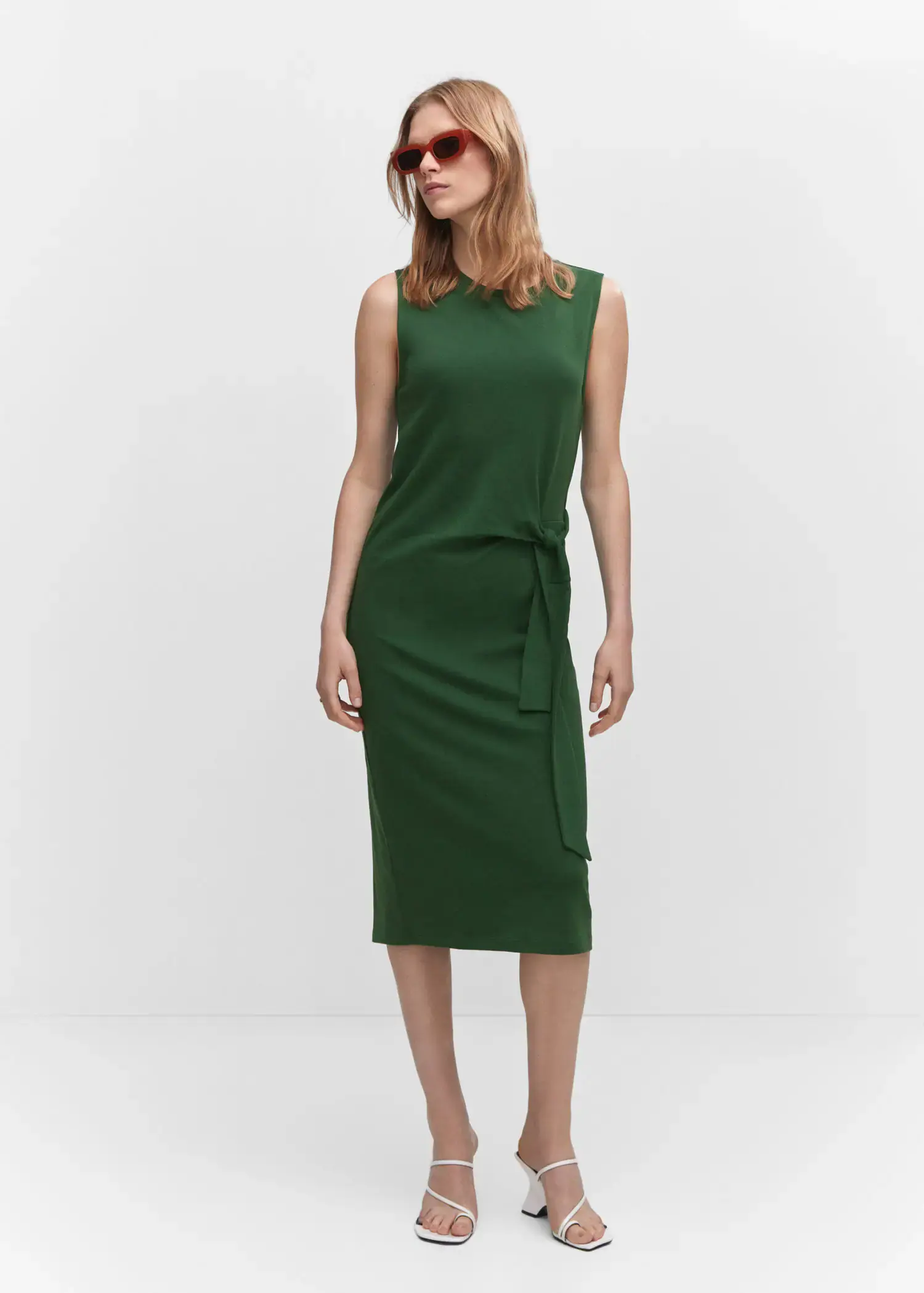 Mango Bow cut-out detail dress. a woman wearing a green dress standing in front of a white wall. 