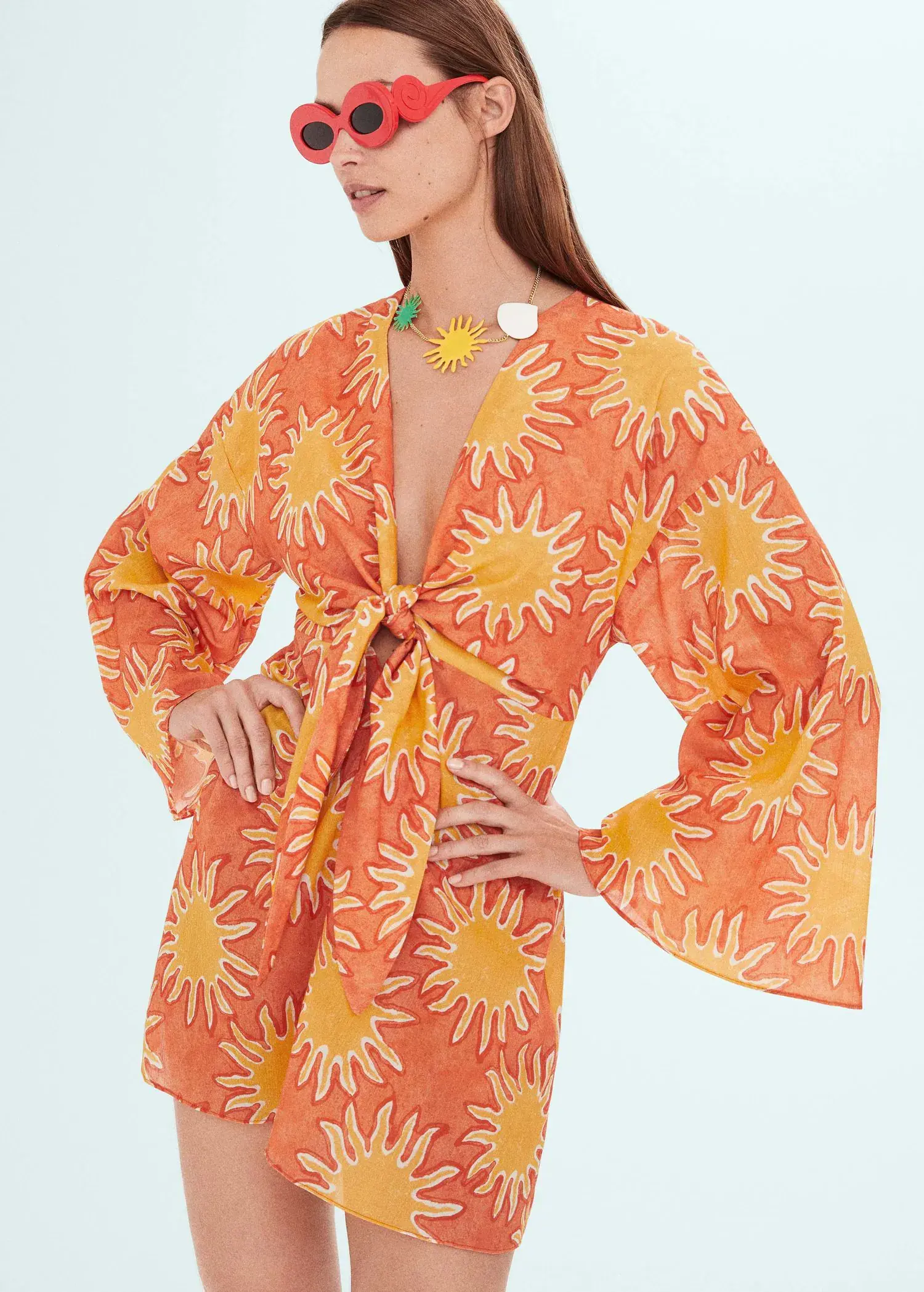 Mango Printed dress with knot detail. a woman in a sun print dress posing for a picture. 