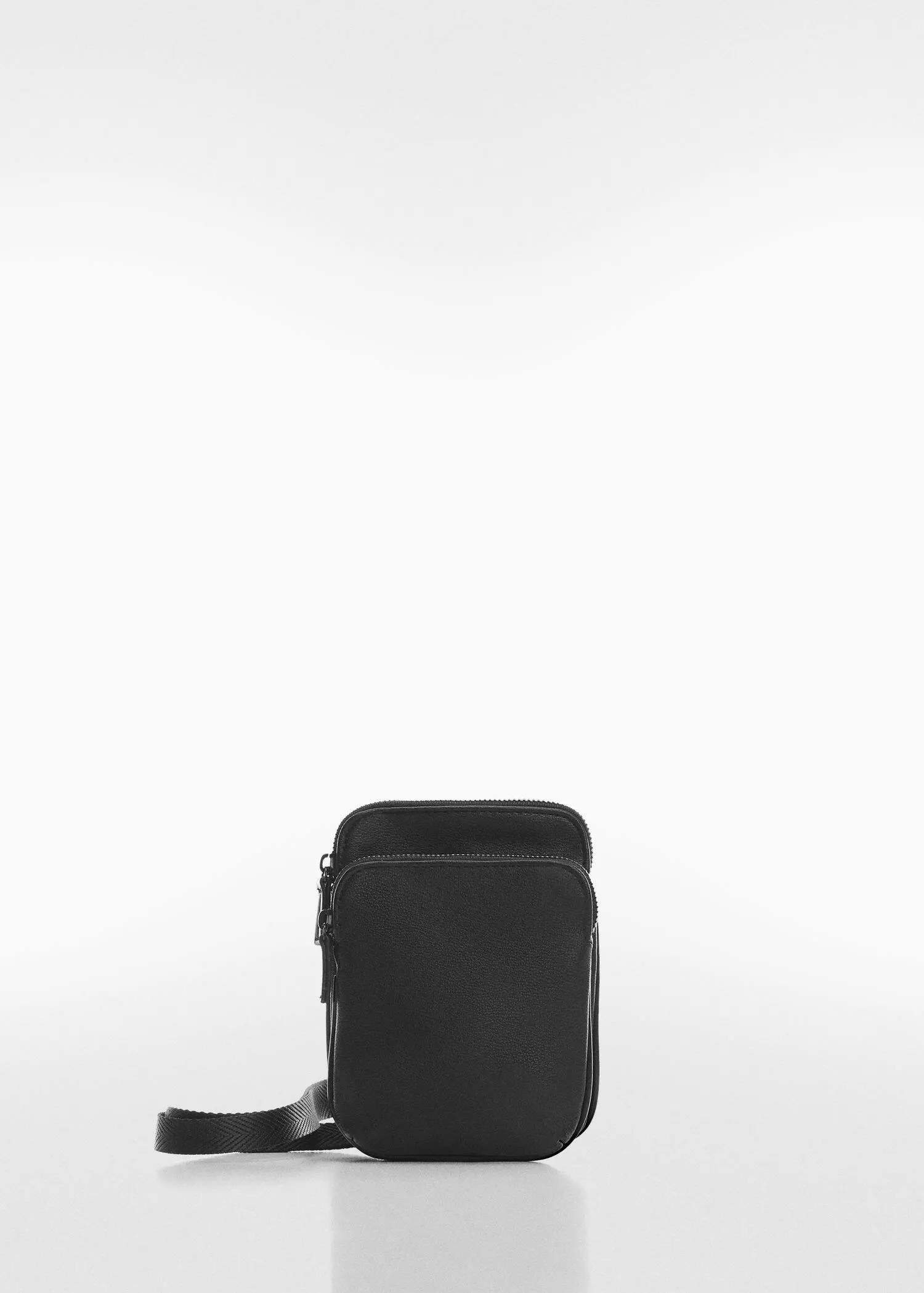 Mango Mini leather-effect shoulder bag. a black bag sitting on top of a white table. 