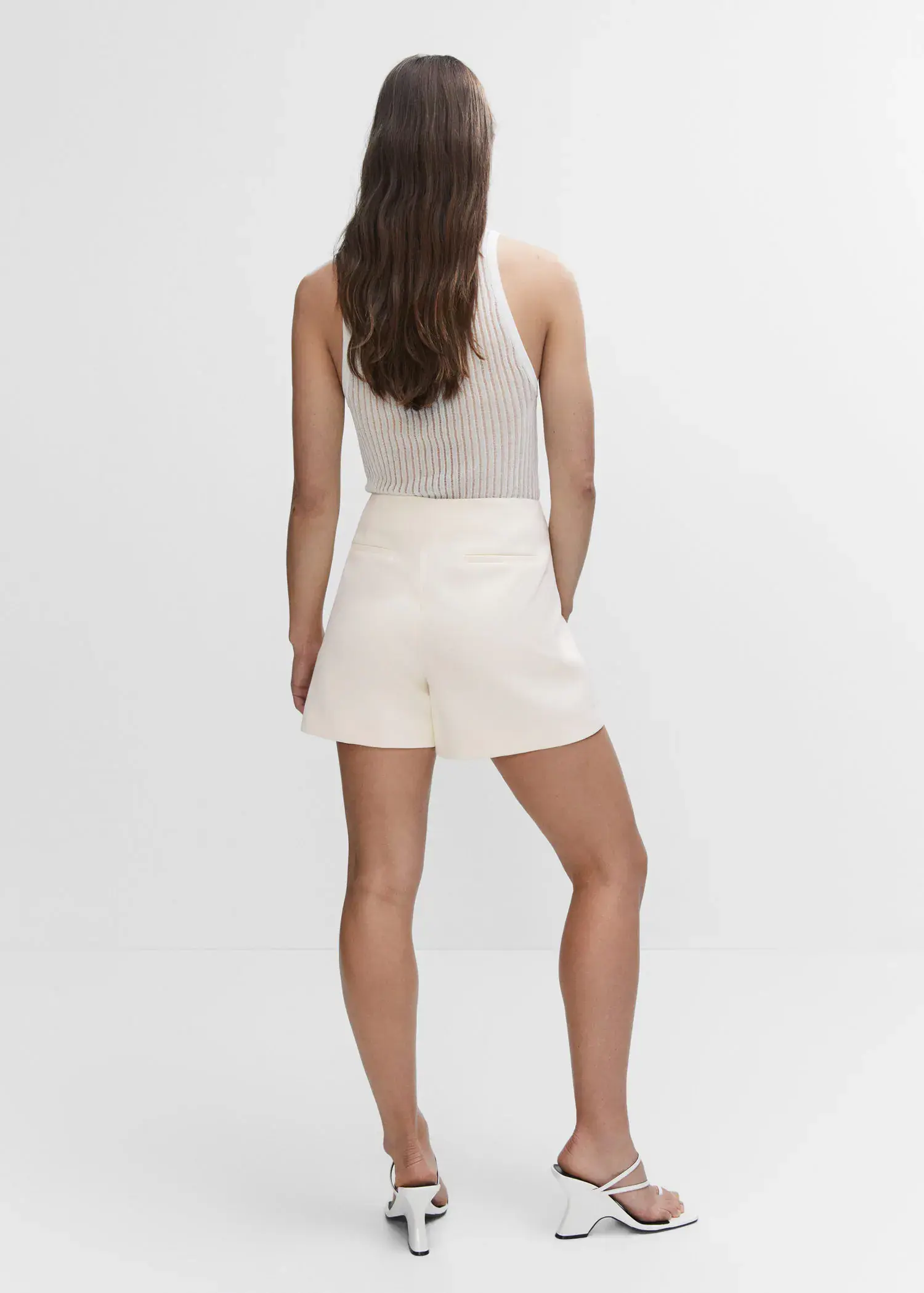 Mango High-waist straight shorts. a woman in a white outfit standing in front of a white wall. 