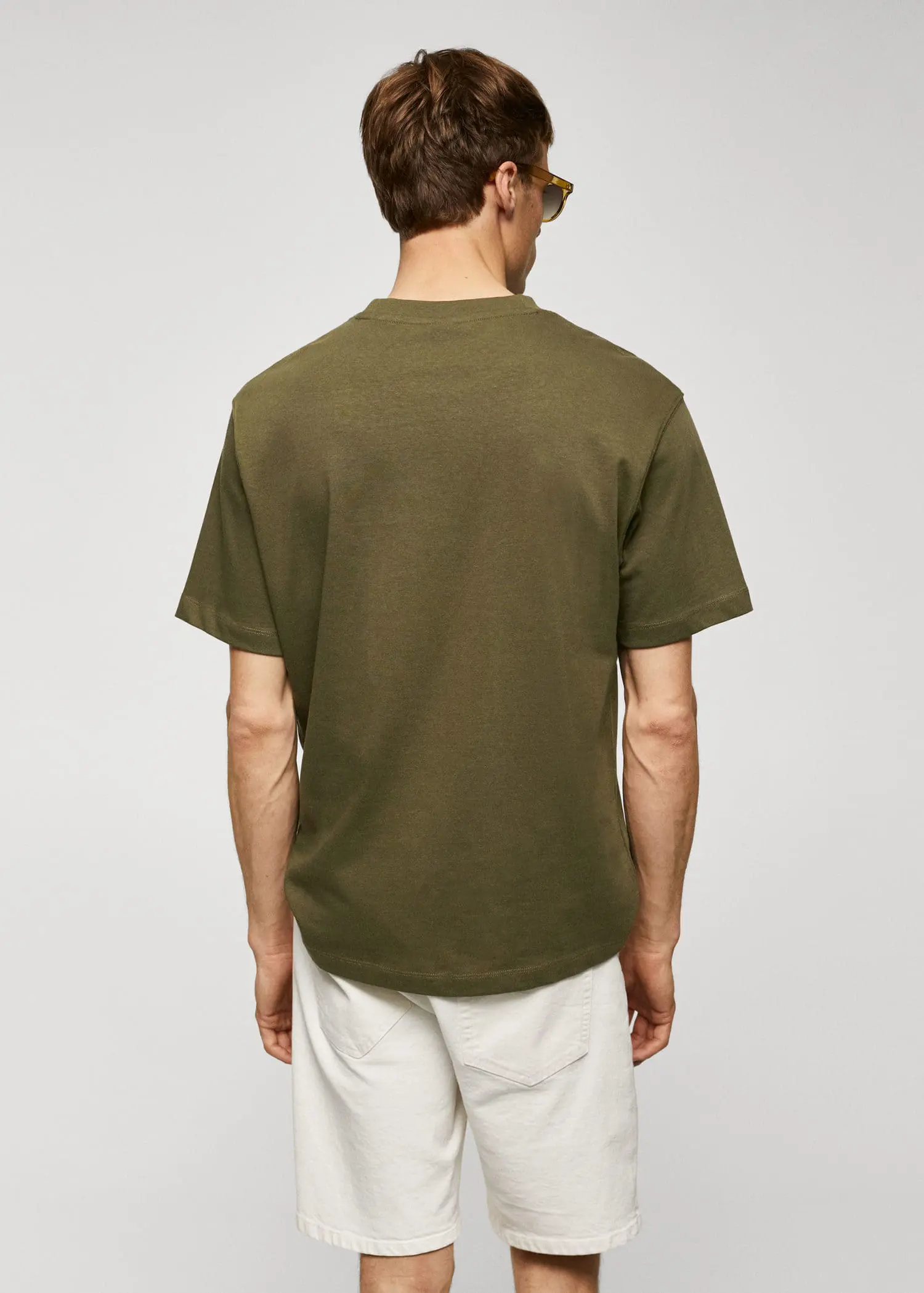 Mango Basic 100% cotton relaxed-fit t-shirt. a man in a green shirt is standing in front of a wall. 