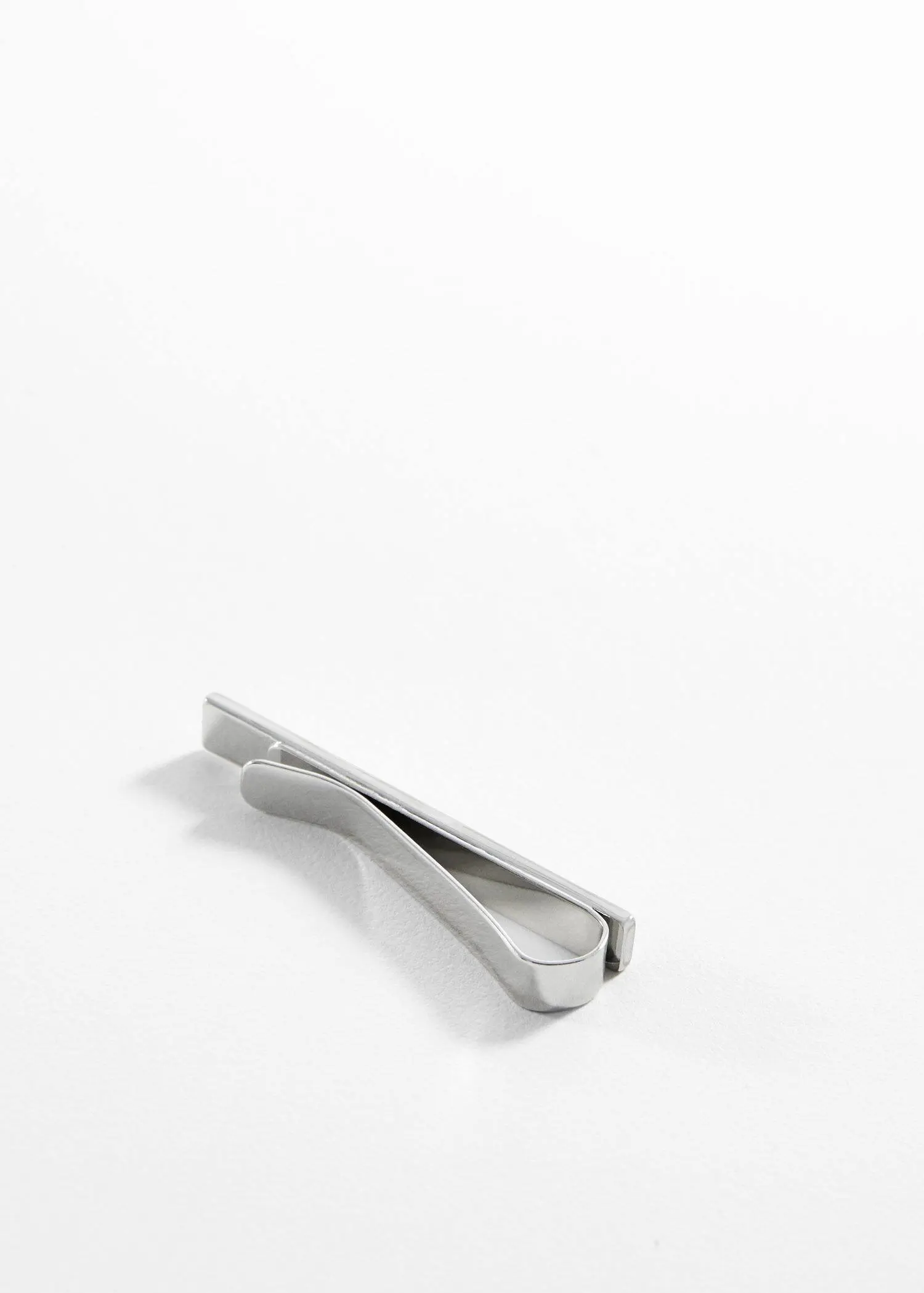Mango Metal tie clip. a metal object sitting on top of a white surface. 