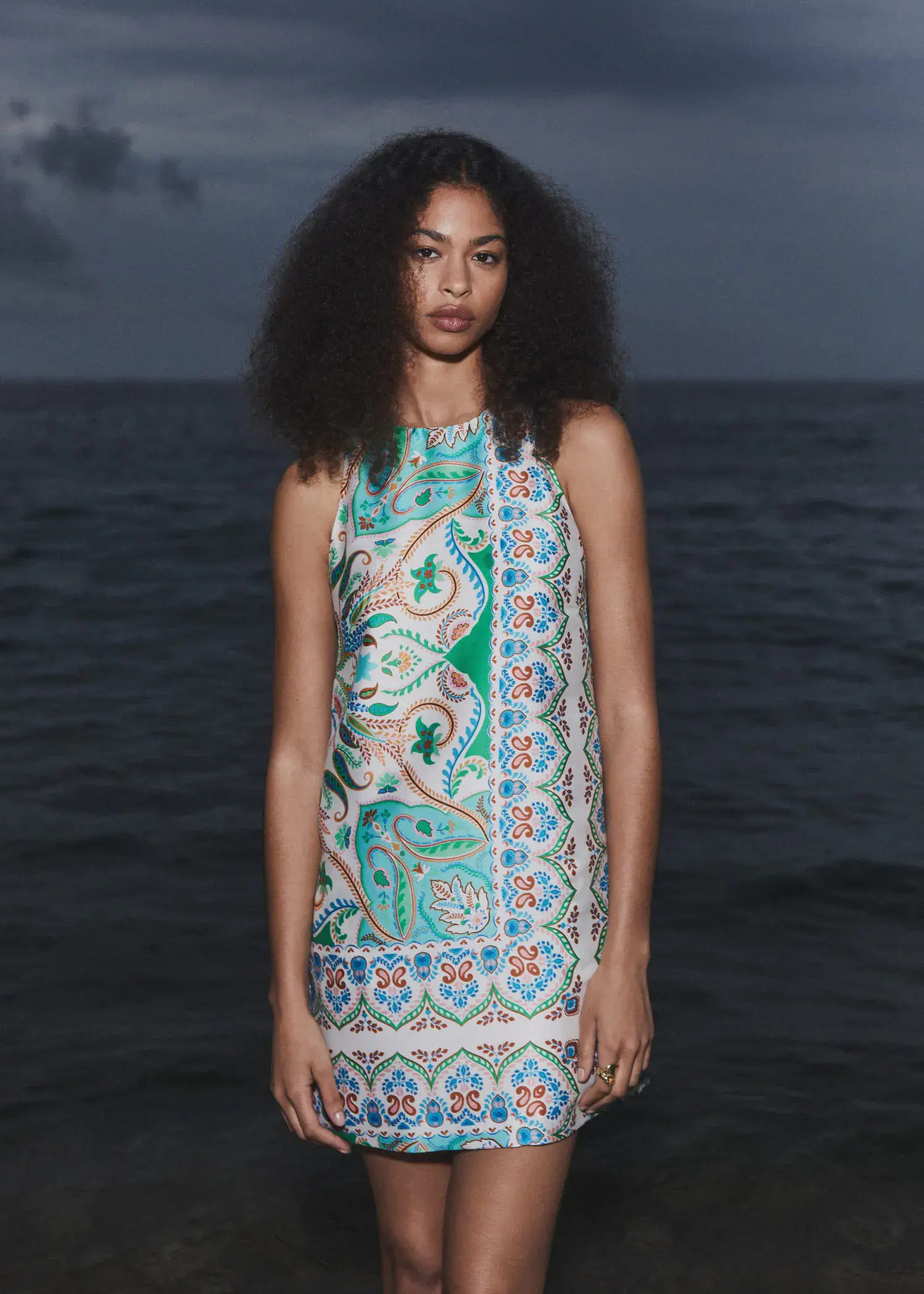 Mango Paisley-print satin dress. a woman standing in front of a body of water. 