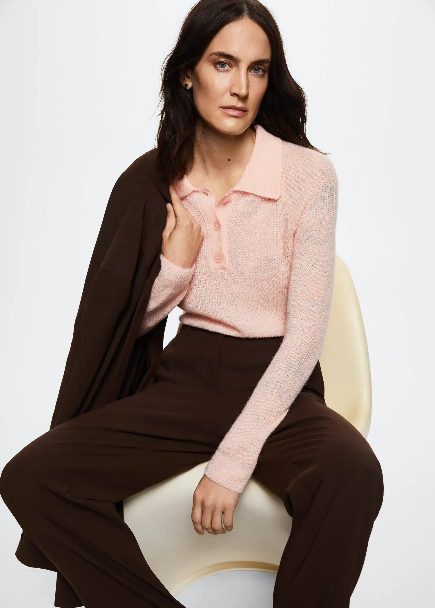 Mango Polo style sweater. a woman sitting on a chair wearing a pink sweater. 