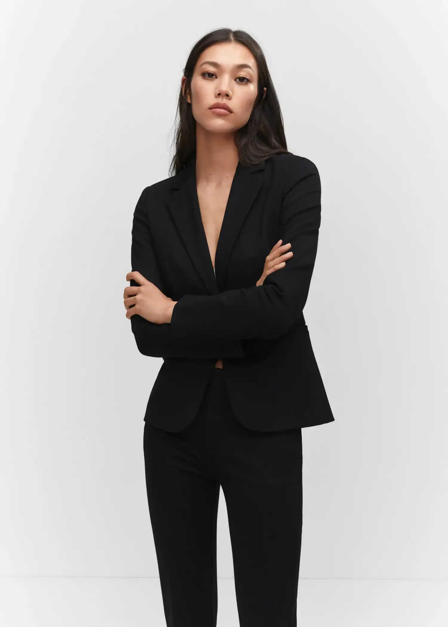 Mango Fitted jacket with blunt stitching. a woman in a black suit posing for a picture. 