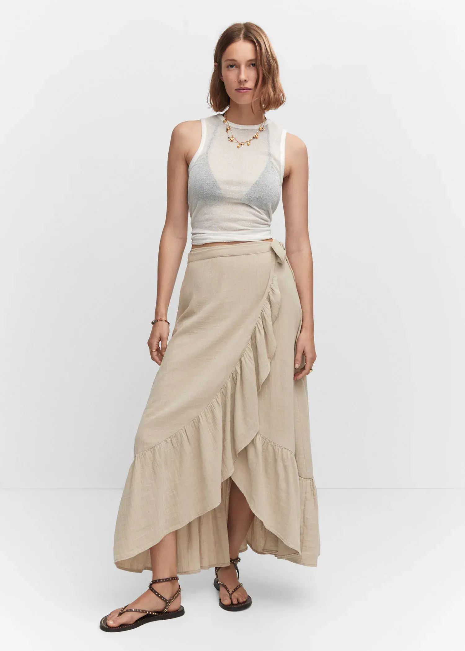 Mango Textured criss-cross skirt. a woman wearing a white top and a beige skirt. 