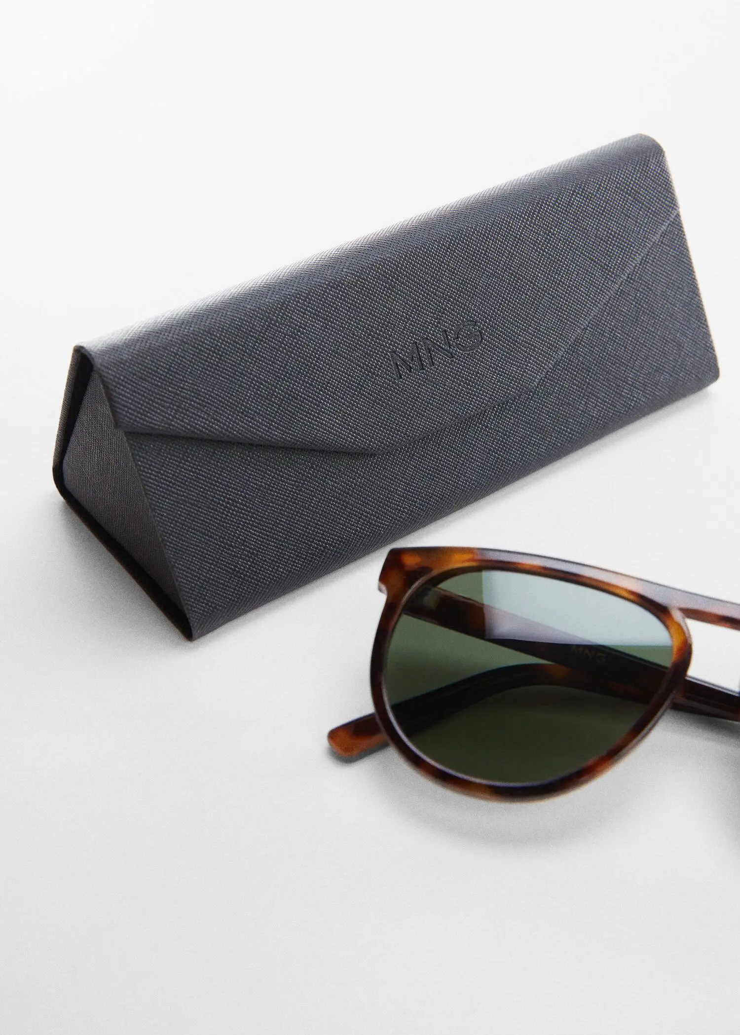 Mango Polarised sunglasses. a pair of sunglasses sitting next to a case. 