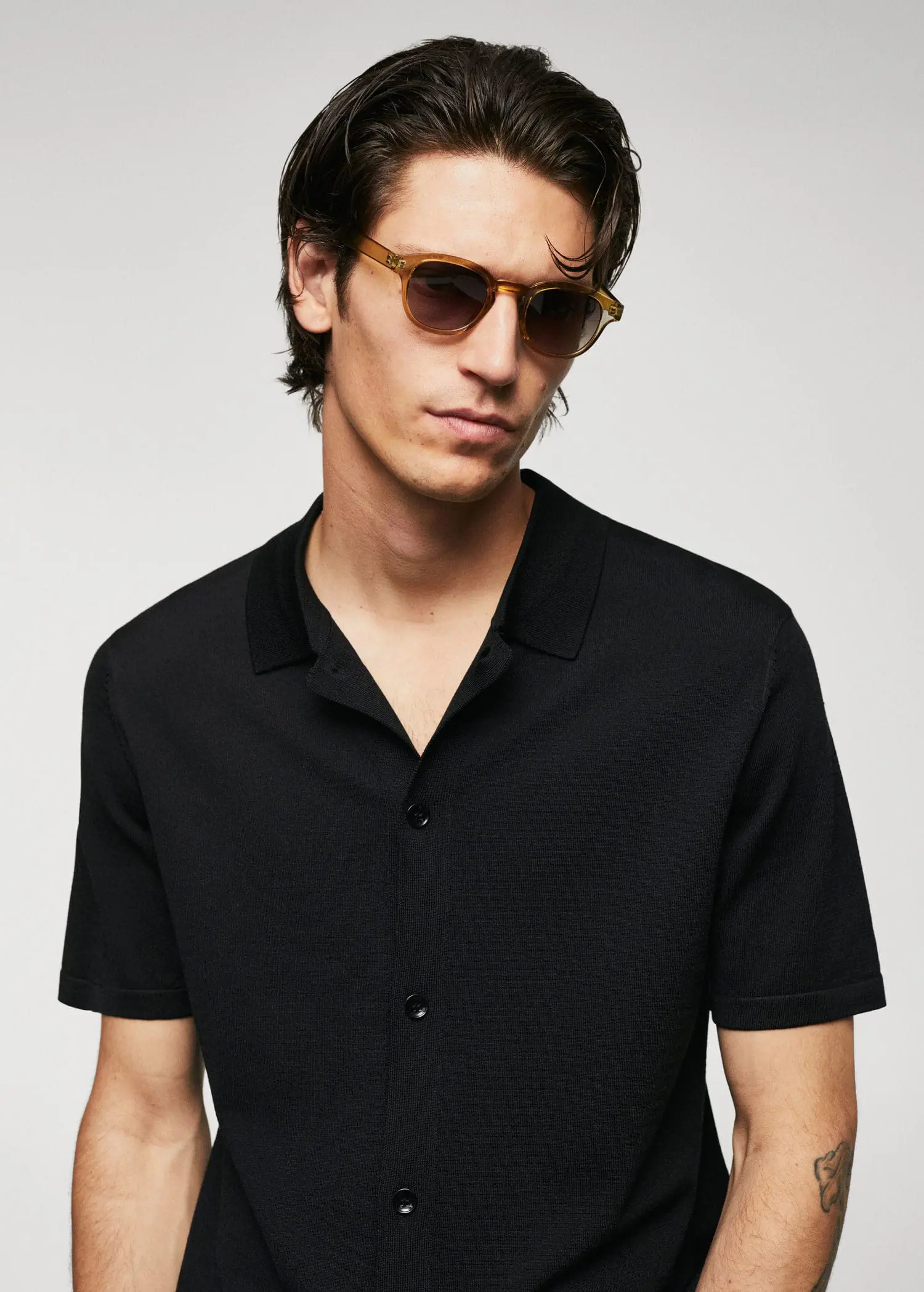 Mango Fine-knit buttoned polo shirt. a young man wearing sunglasses and a black shirt. 