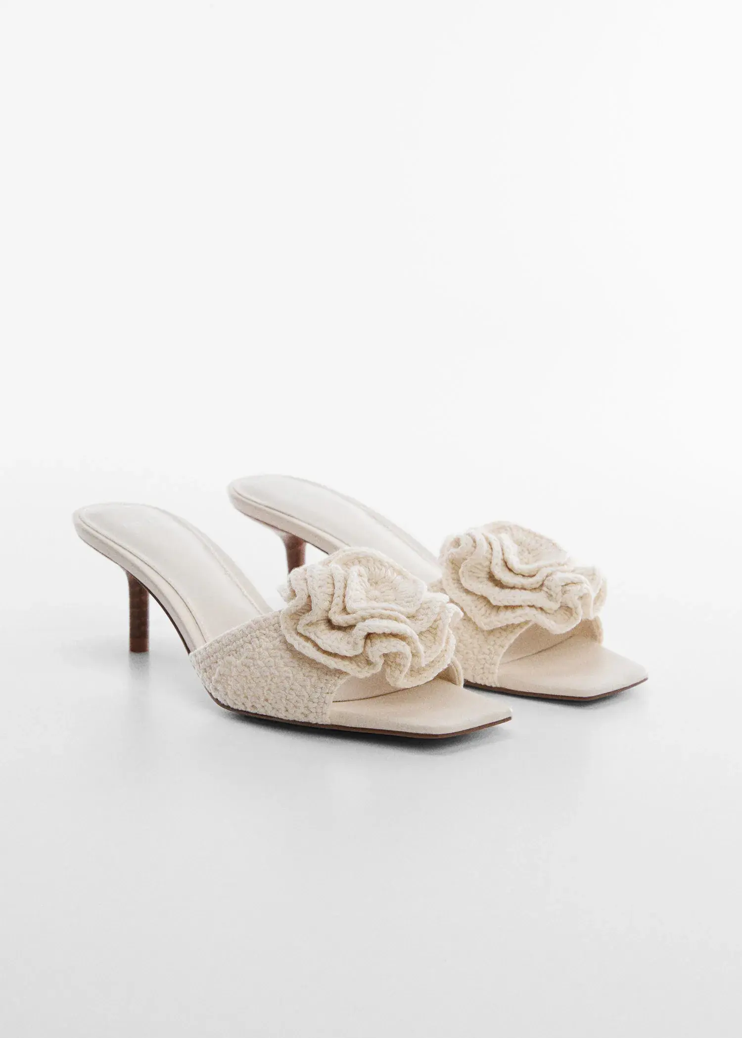 Mango Crochet flower sandal. a pair of white high heeled shoes on a white surface. 