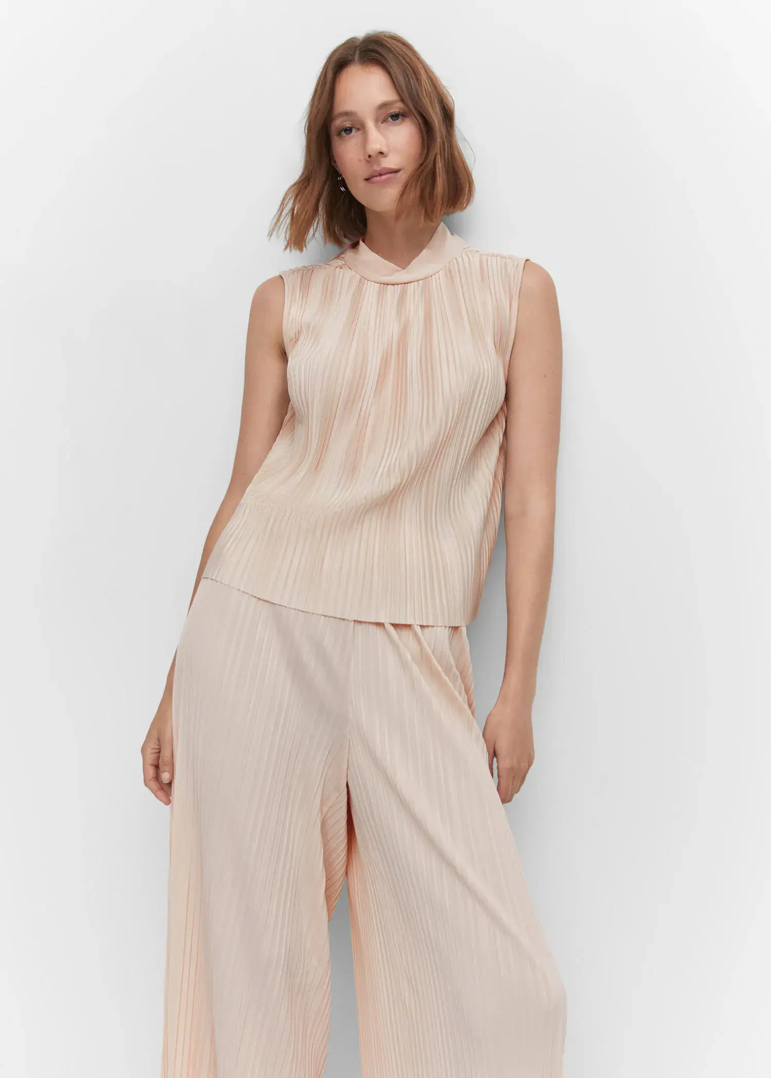 Mango Pleated bow top. a woman wearing a light pink top and pants. 