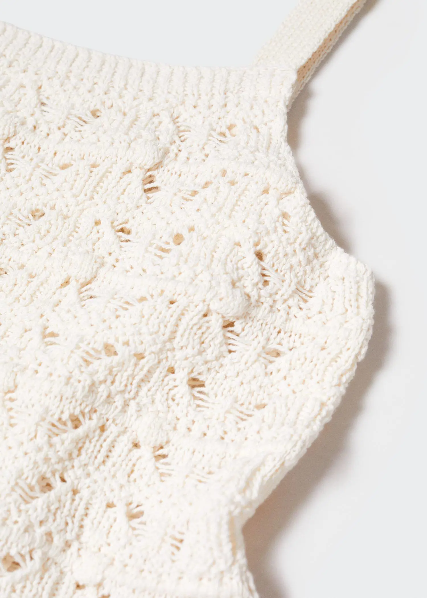 Mango Crochet top. a close-up view of a crocheted item on a table. 