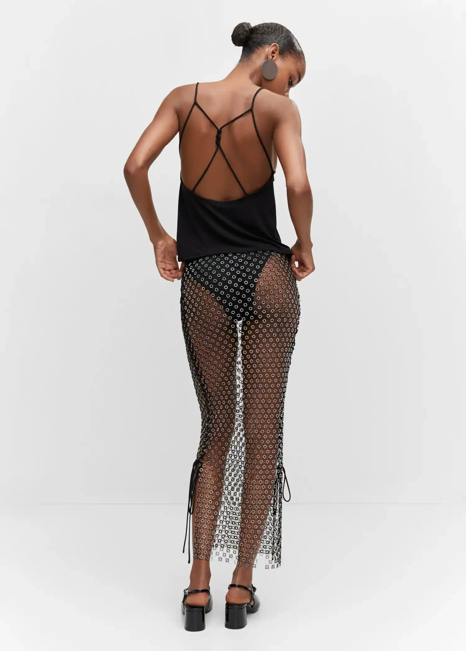 Mango Wrap back top. a woman in a black top and fishnet skirt. 