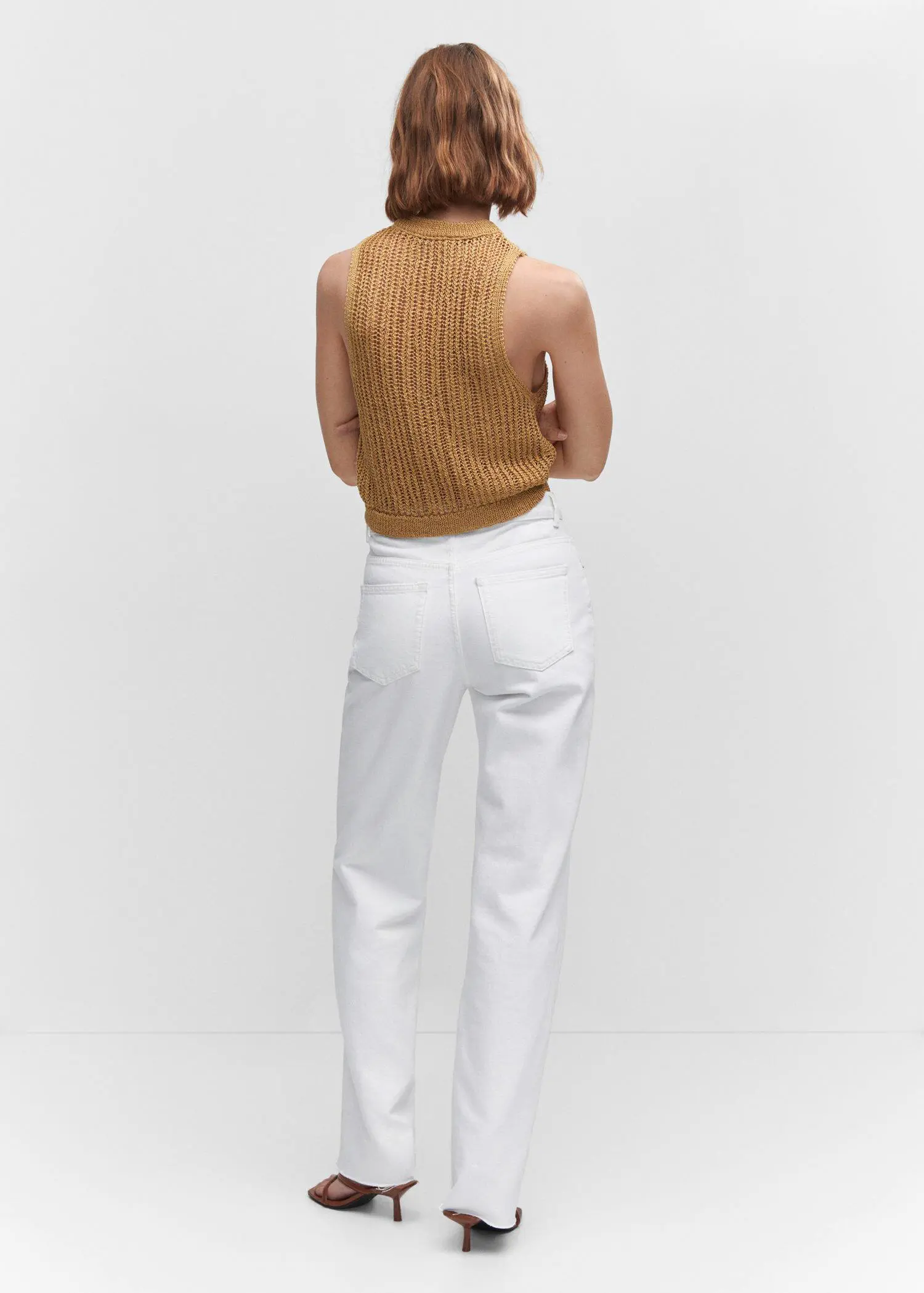 Mango Wideleg mid-rise jeans. a woman standing in front of a white wall wearing white pants. 