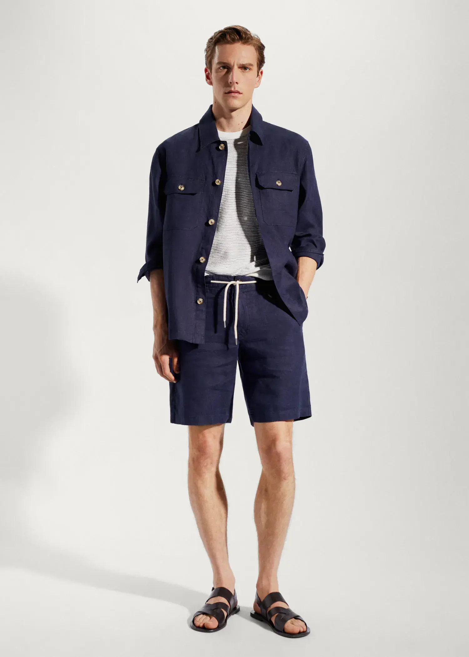Mango 100% linen regular-fit overshirt. a man in a blue jacket and shorts. 