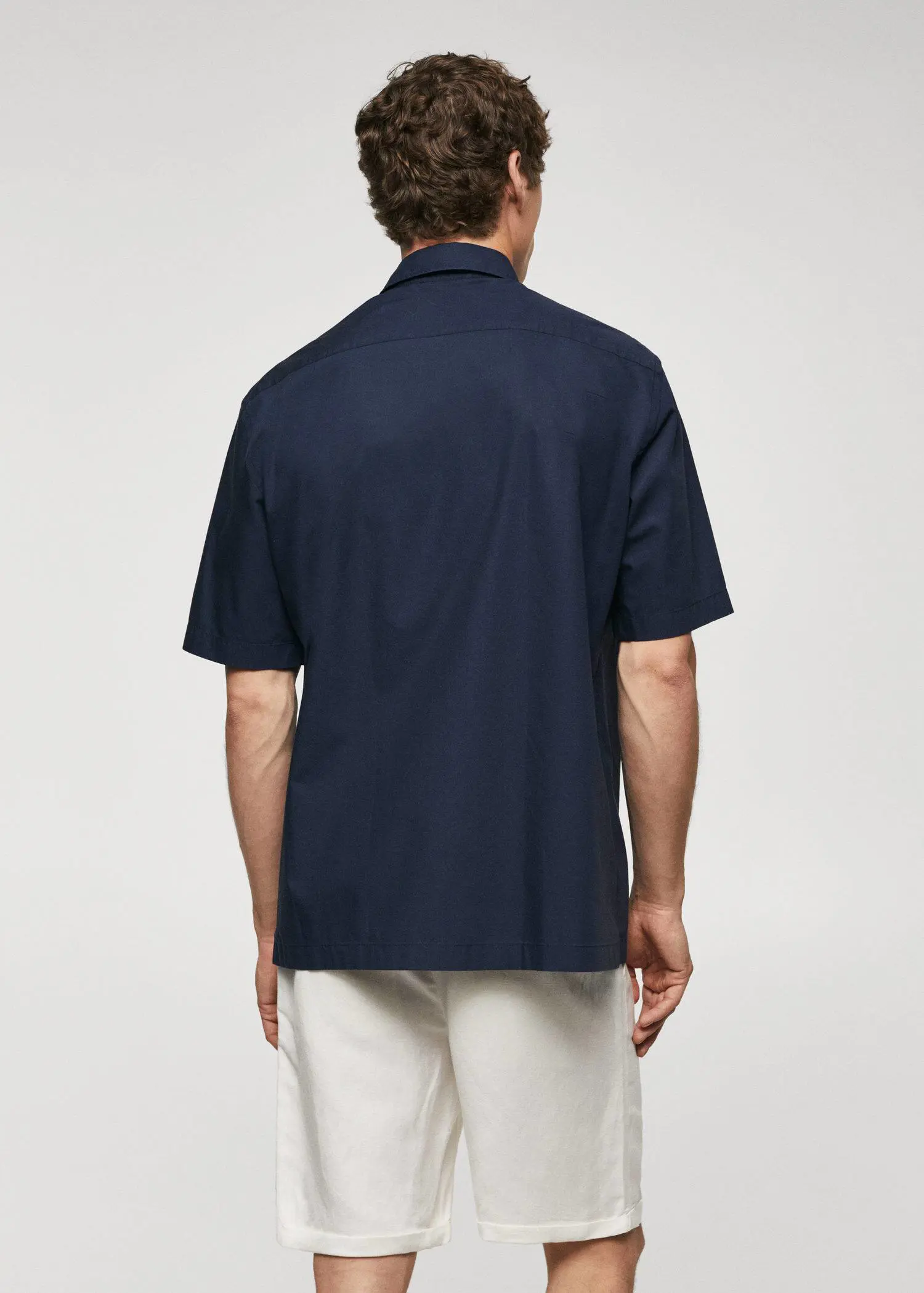 Mango Regular-fit cotton short sleeve shirt. a man wearing a blue shirt and white pants. 