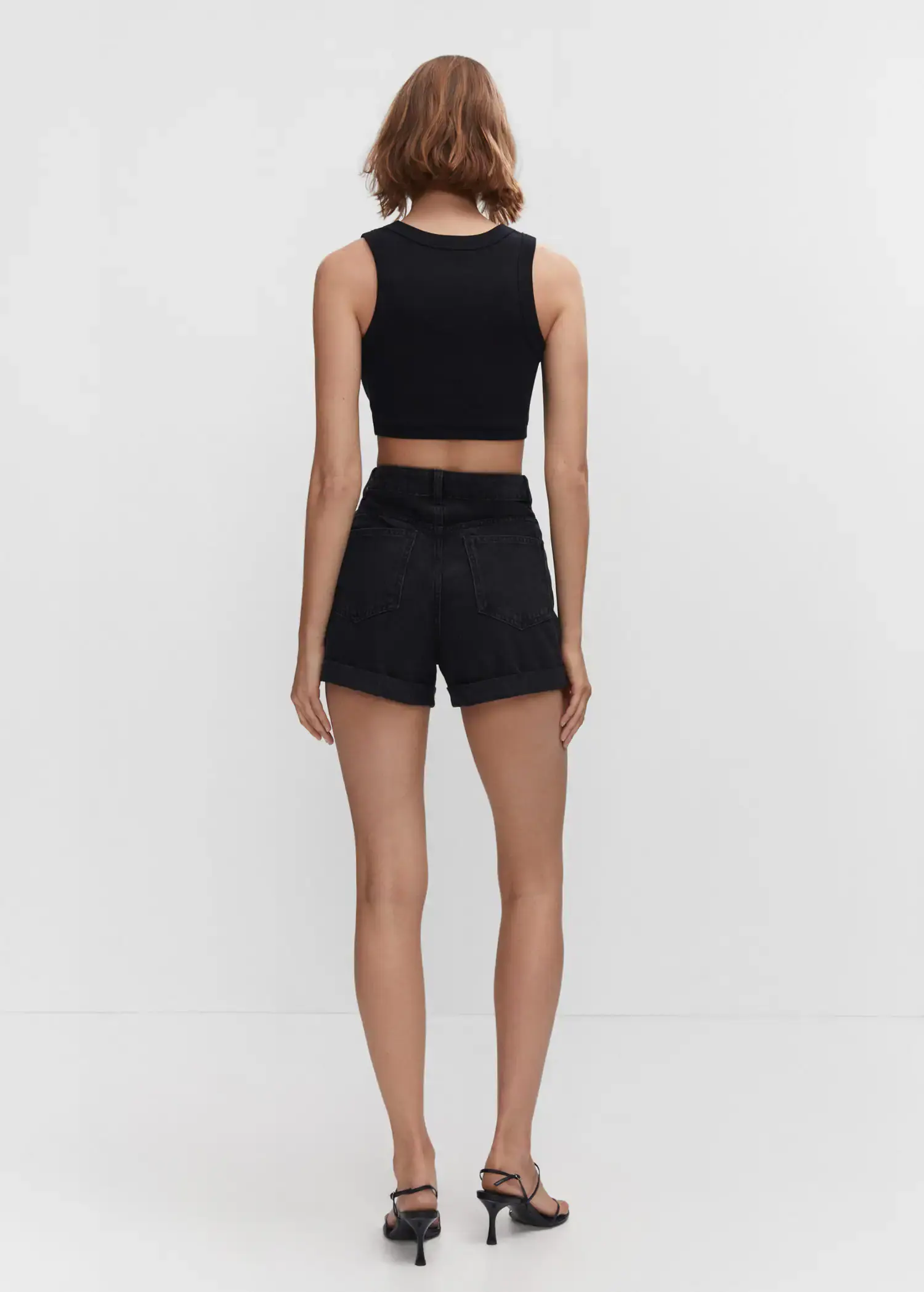 Mango Mom-fit denim shorts. a woman wearing black shorts and a crop top. 