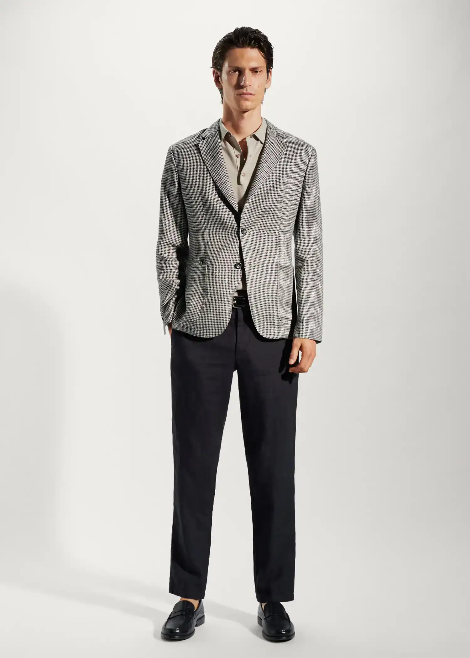 Mango 100% linen micro-houndstooth jacket. a man wearing a suit and tie standing in front of a white wall. 