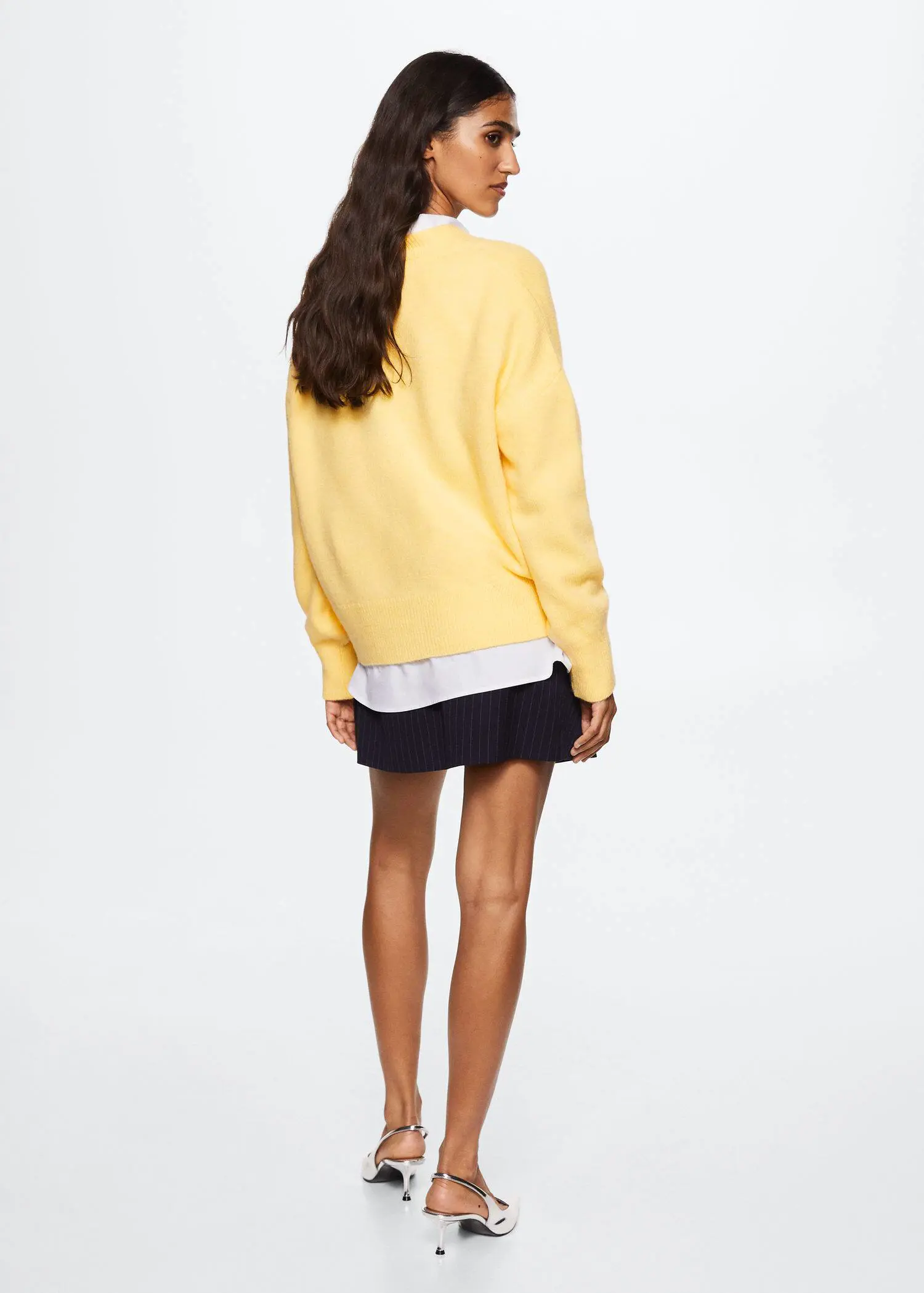 Mango V-neck knit sweater. a woman wearing a yellow sweater and black skirt. 