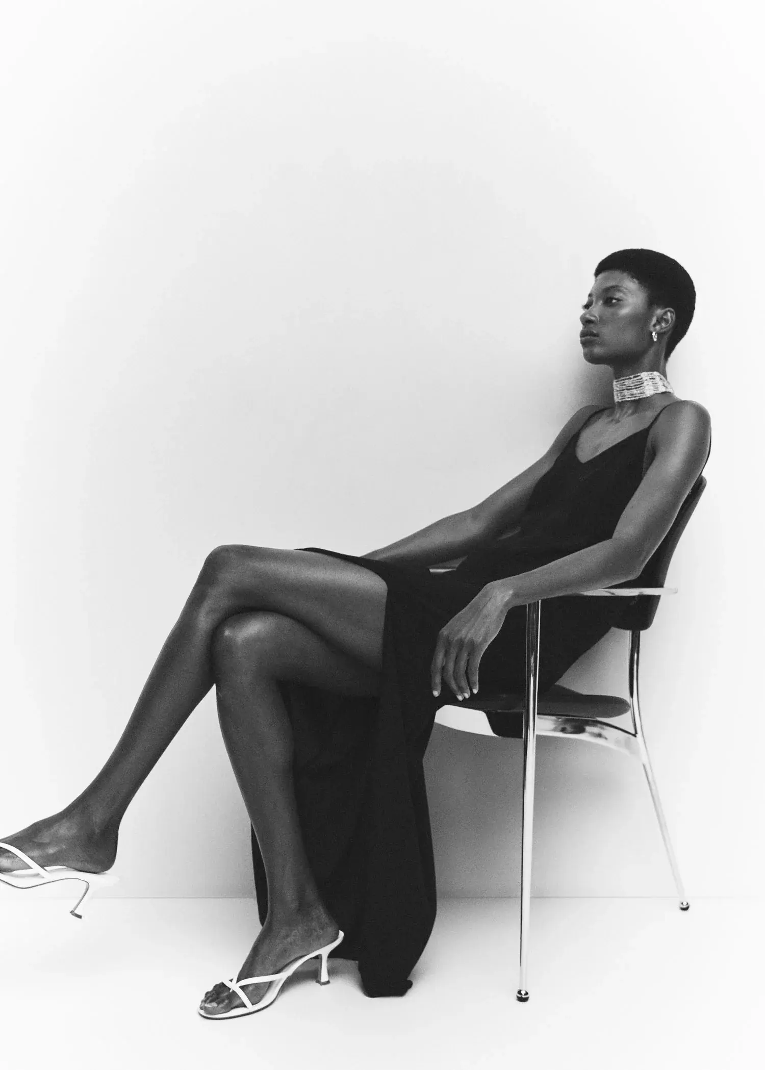 Mango Slit long dress. a woman sitting on a chair in a black dress. 