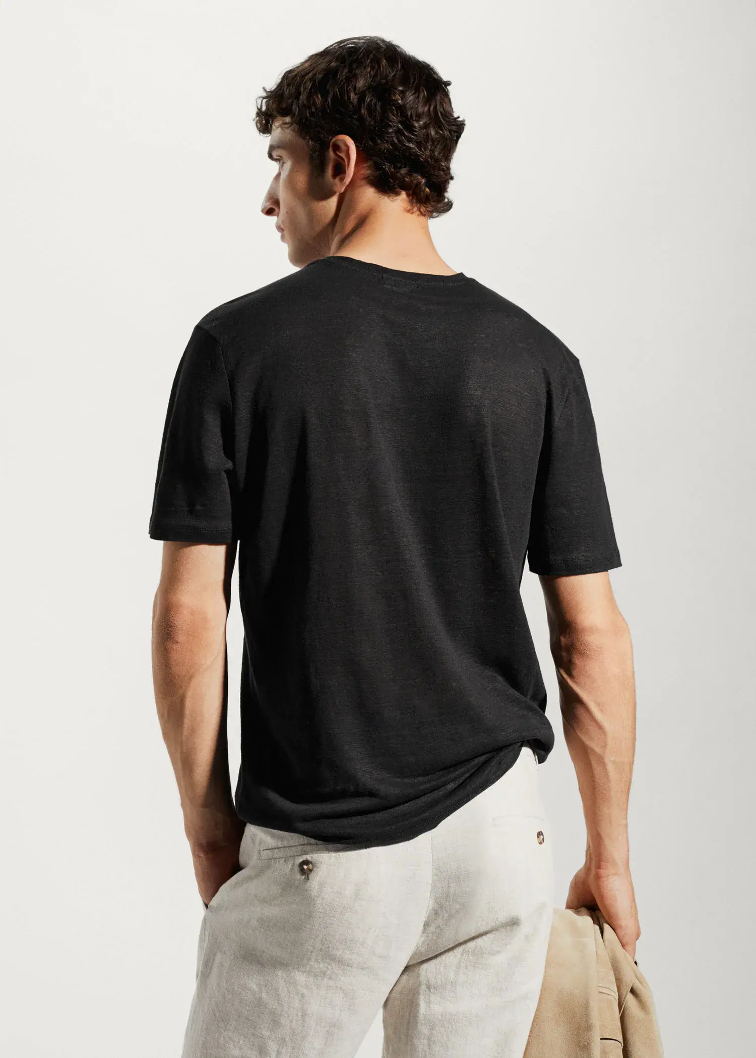 Mango 100% linen slim-fit t-shirt. a man wearing a black shirt and white shorts. 