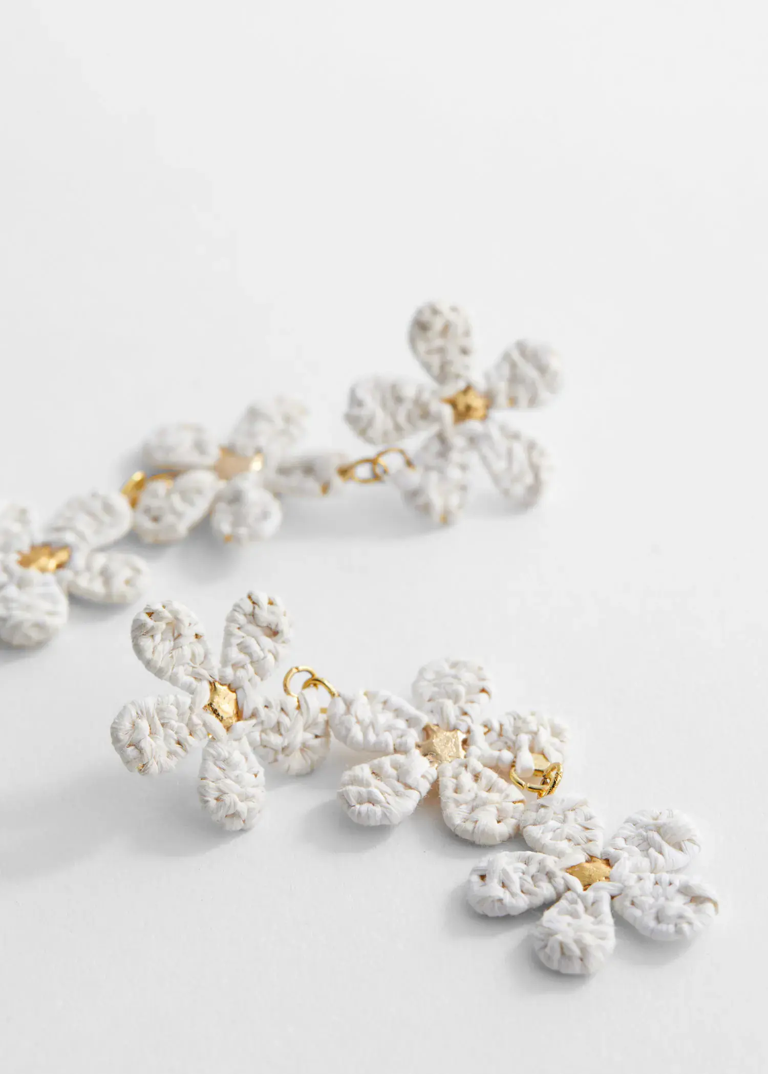 Mango Flowers raffia earrings. a close up of a pair of earrings on a table 