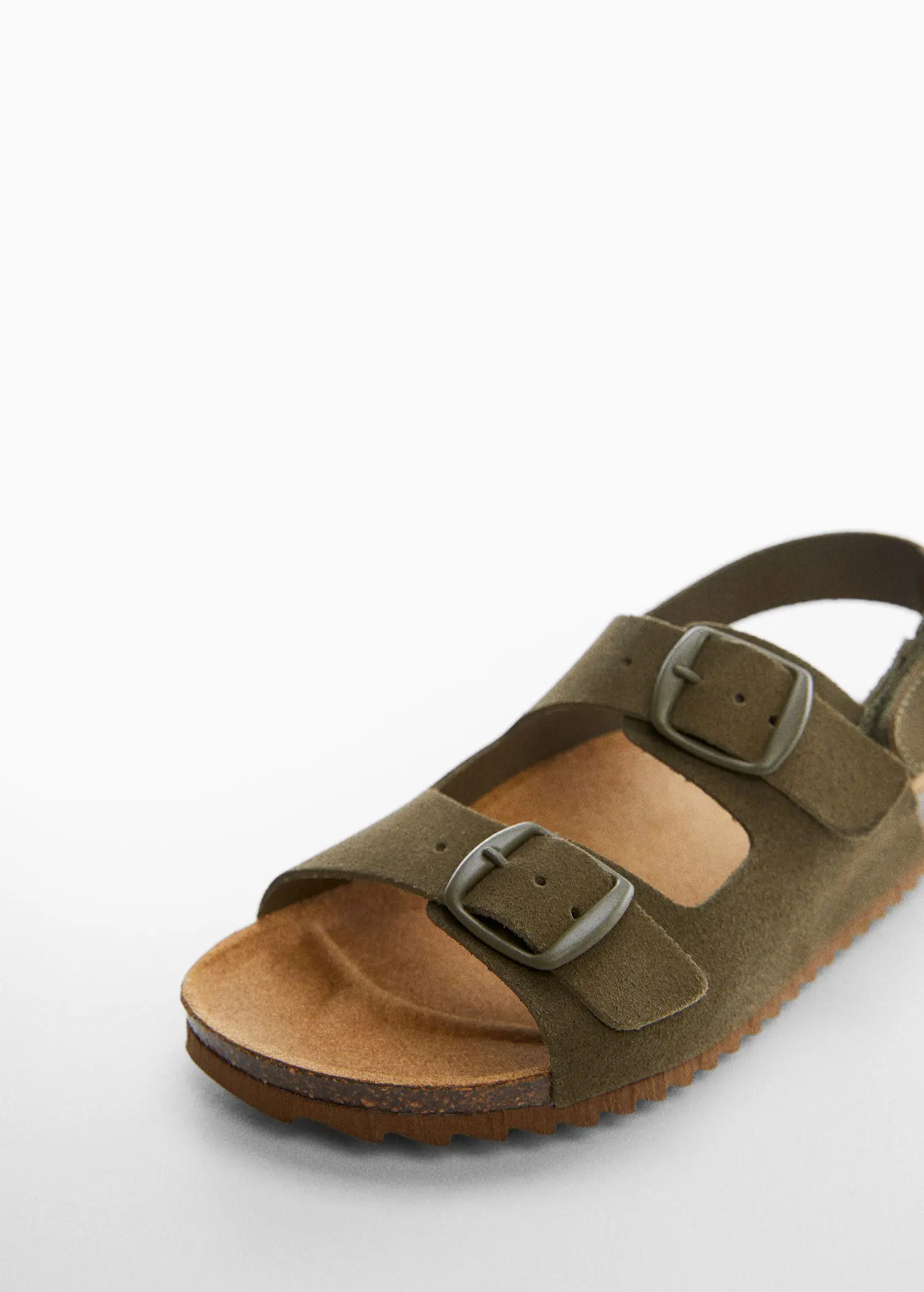 Mango Buckles leather sandal. a close up of a pair of sandals on the ground 