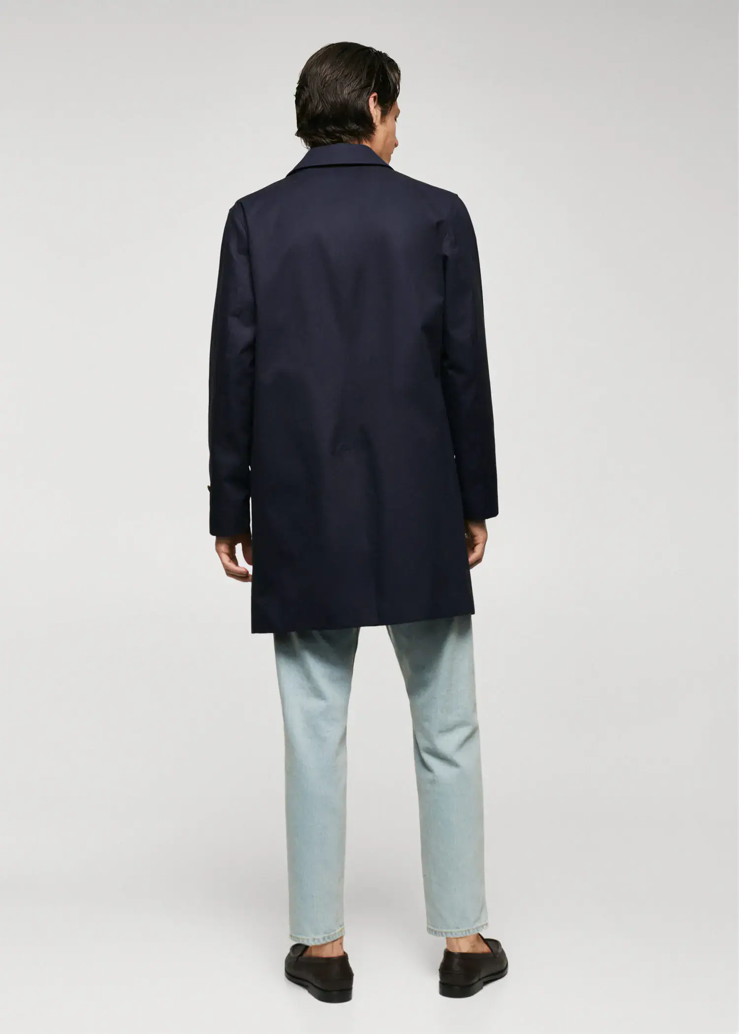 Mango Water-repellent cotton trench coat. a man wearing a black coat and blue pants. 