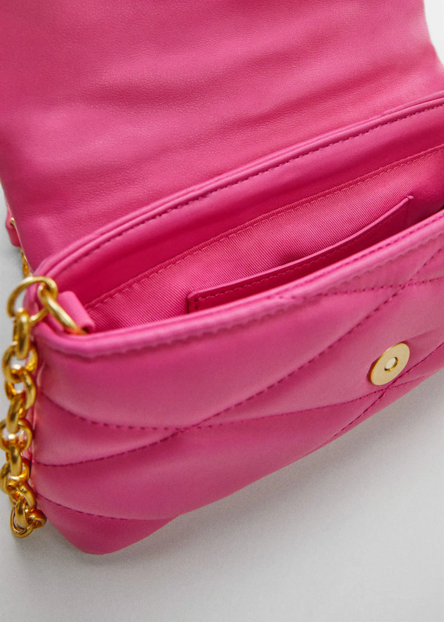 Mango Quilted chain bag. a close-up of the inside of a pink purse. 