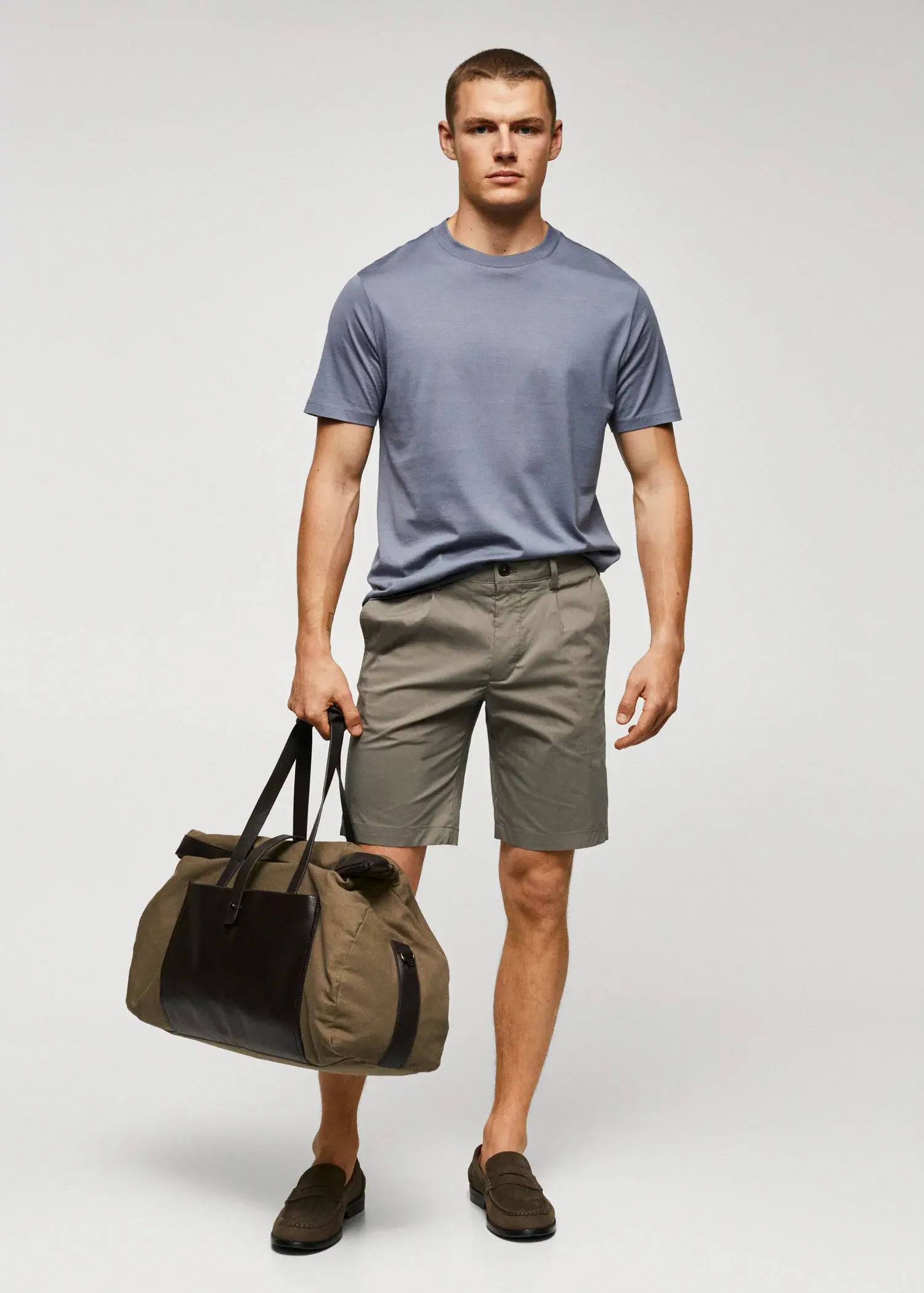 Mango Cotton pleated Bermuda shorts. a man in shorts and a t-shirt is holding a bag. 
