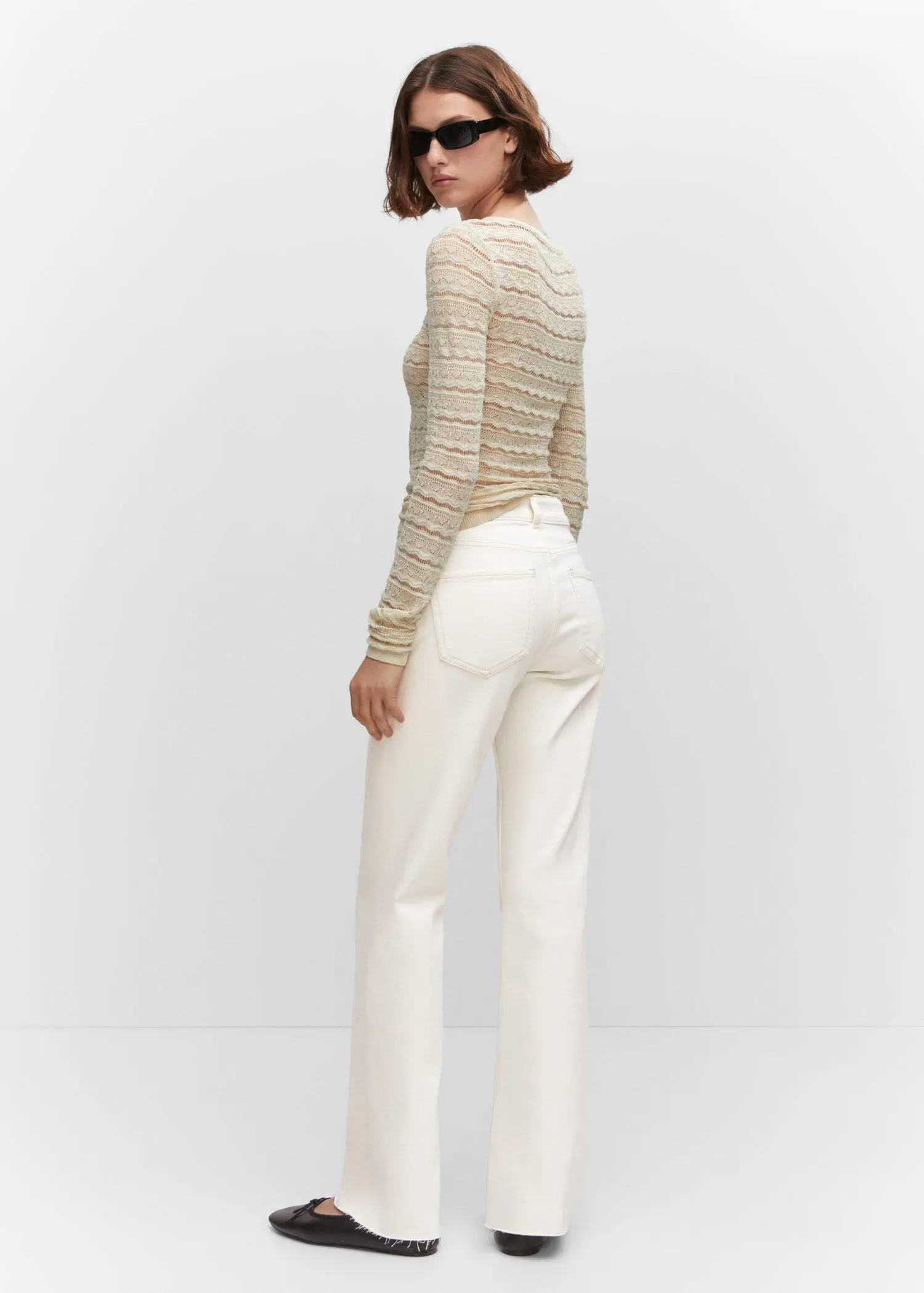 Mango Medium-rise straight jeans with slits. a woman wearing white pants and a sweater. 