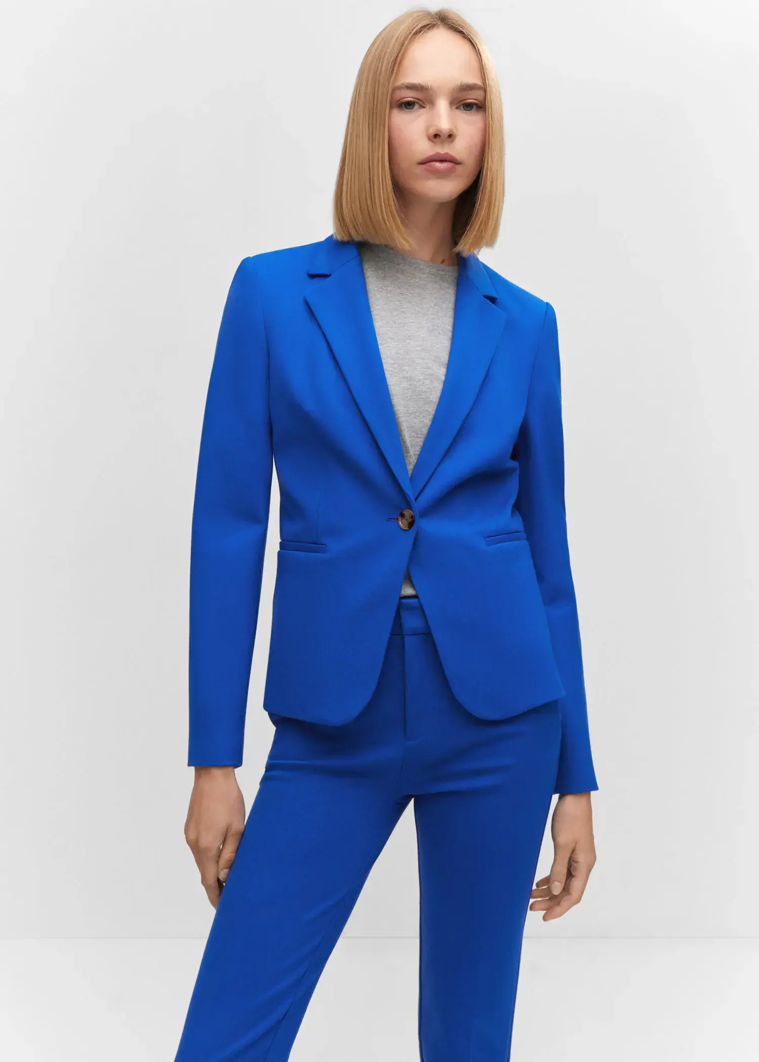 Mango Fitted jacket with blunt stitching. a woman wearing a blue jacket and pants. 