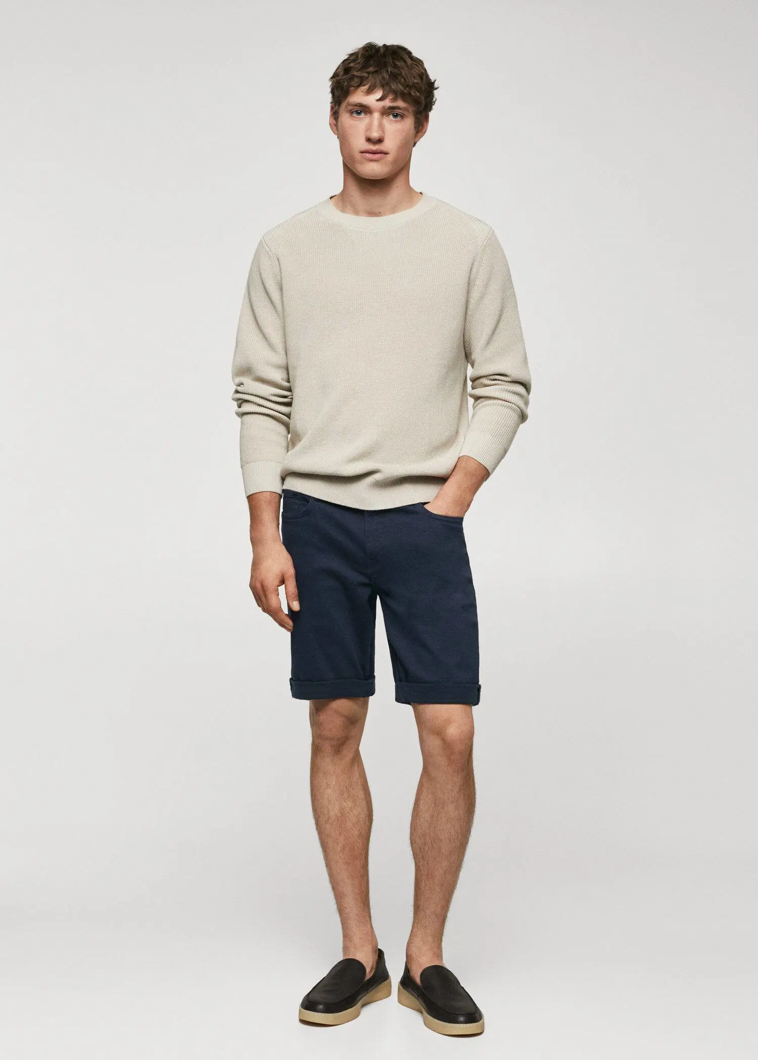 Mango Slim-fit denim bermuda shorts. a man in a white sweater and blue shorts. 