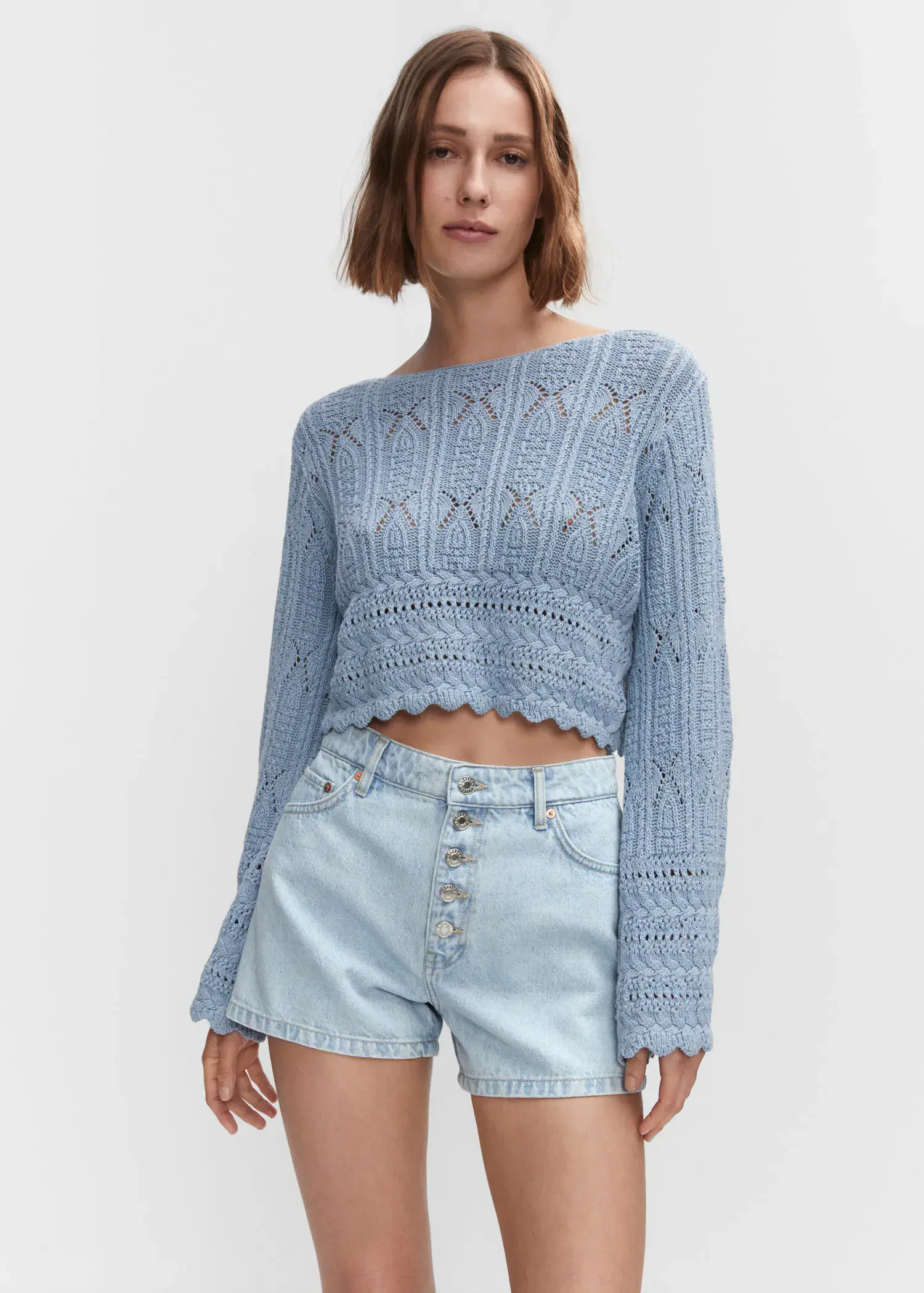 Mango Denim shorts with buttons. a woman in a light blue sweater and light blue denim shorts. 