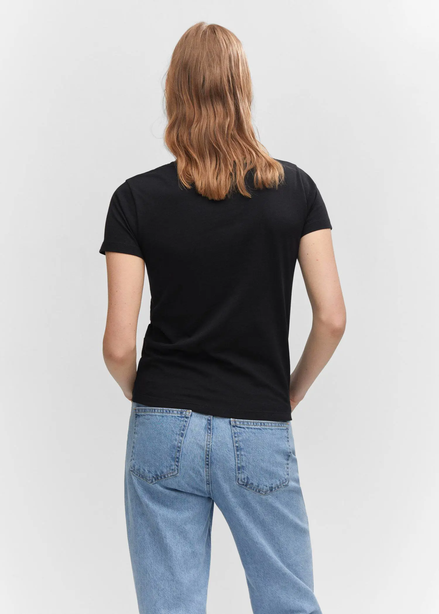 Mango Metallic logo T-shirt. a woman wearing a black t-shirt and blue jeans. 
