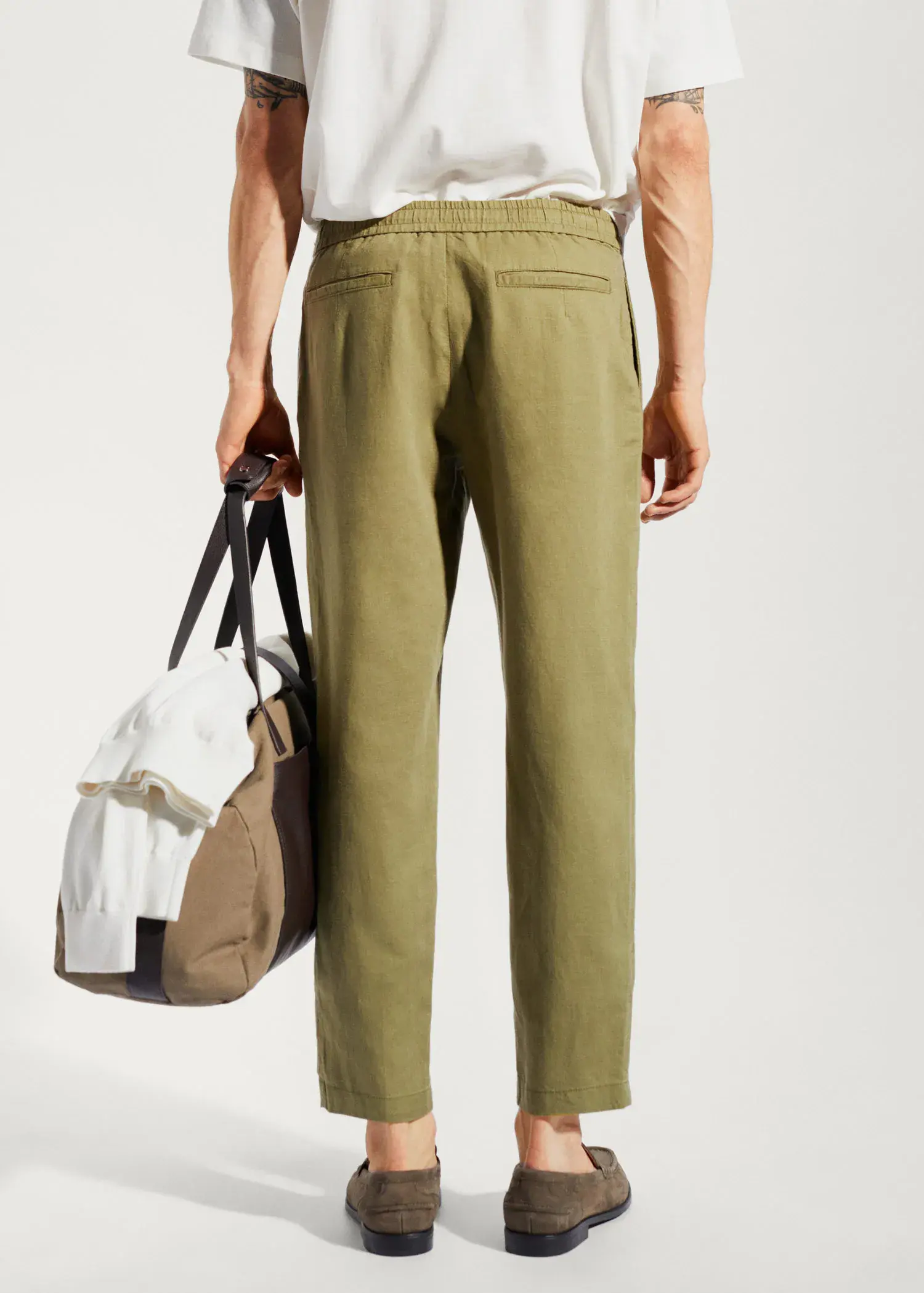 Mango Slim-fit pants with drawstring . a person holding a bag in their hand. 