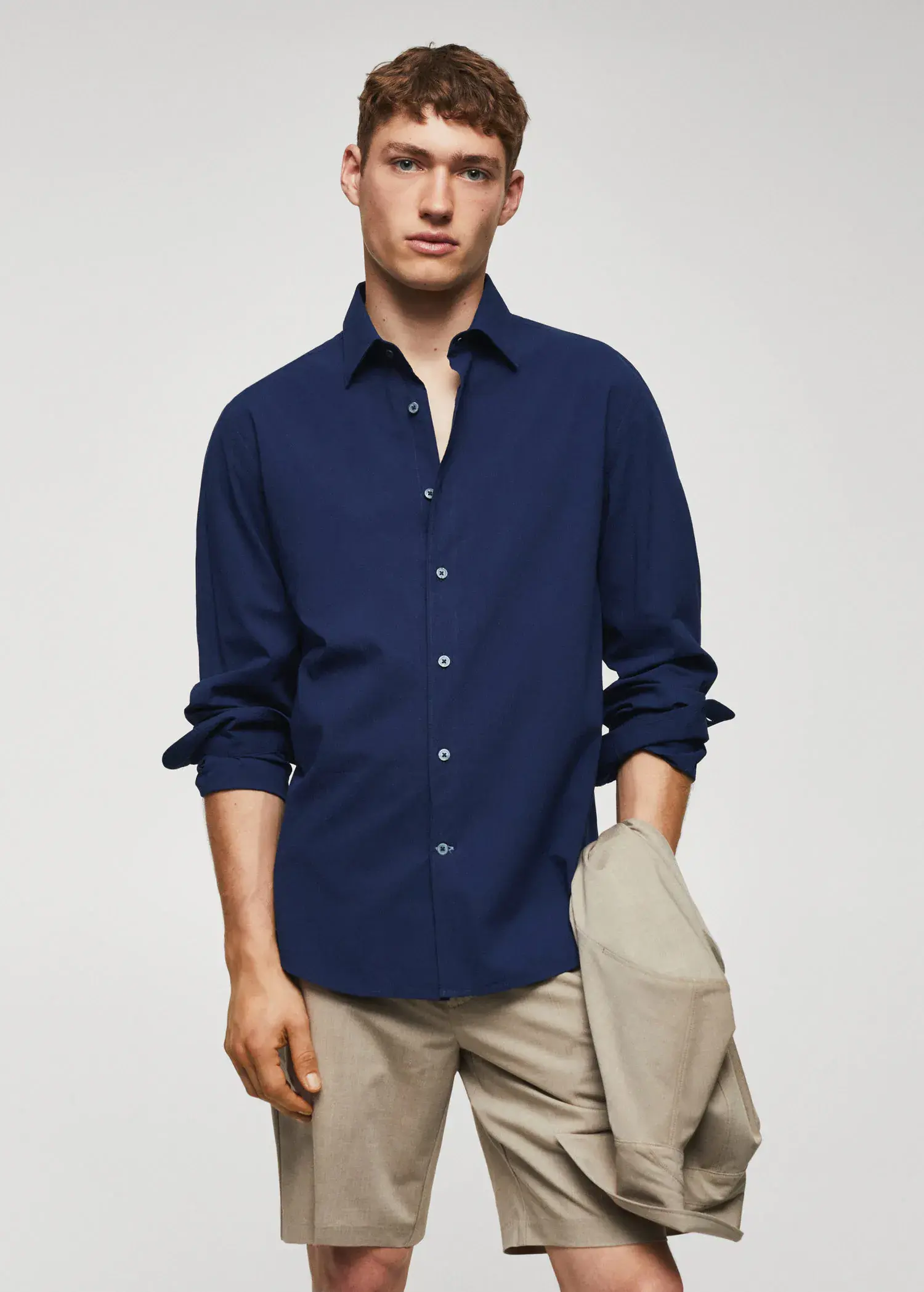 Mango Slim-fit cotton seersucker shirt. a man wearing a blue shirt and beige pants. 
