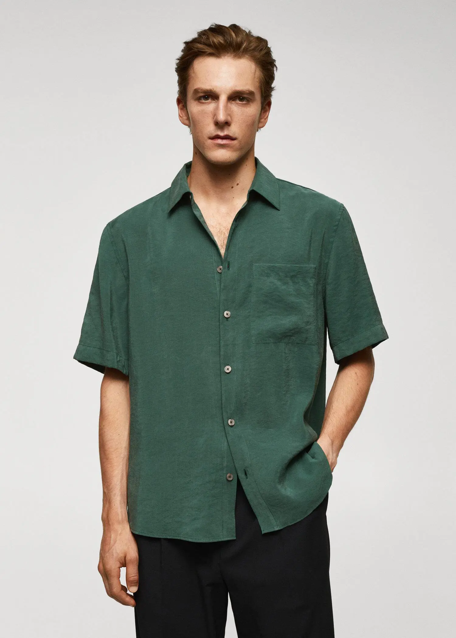 Mango Regular-fit short-sleeved shirt. a man wearing a green shirt and black pants. 