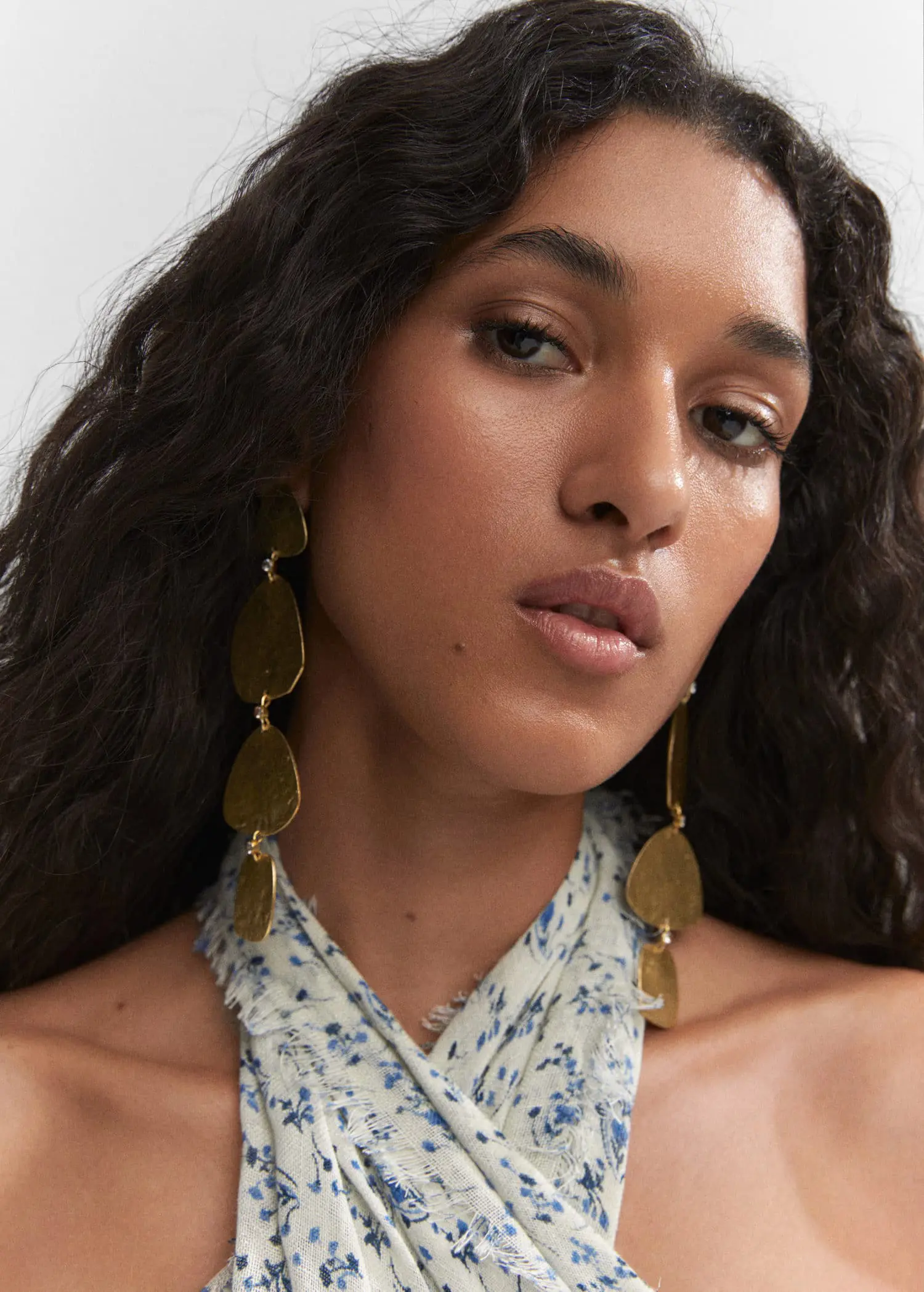 Mango Textured earrings. a close up of a person with long curly hair 