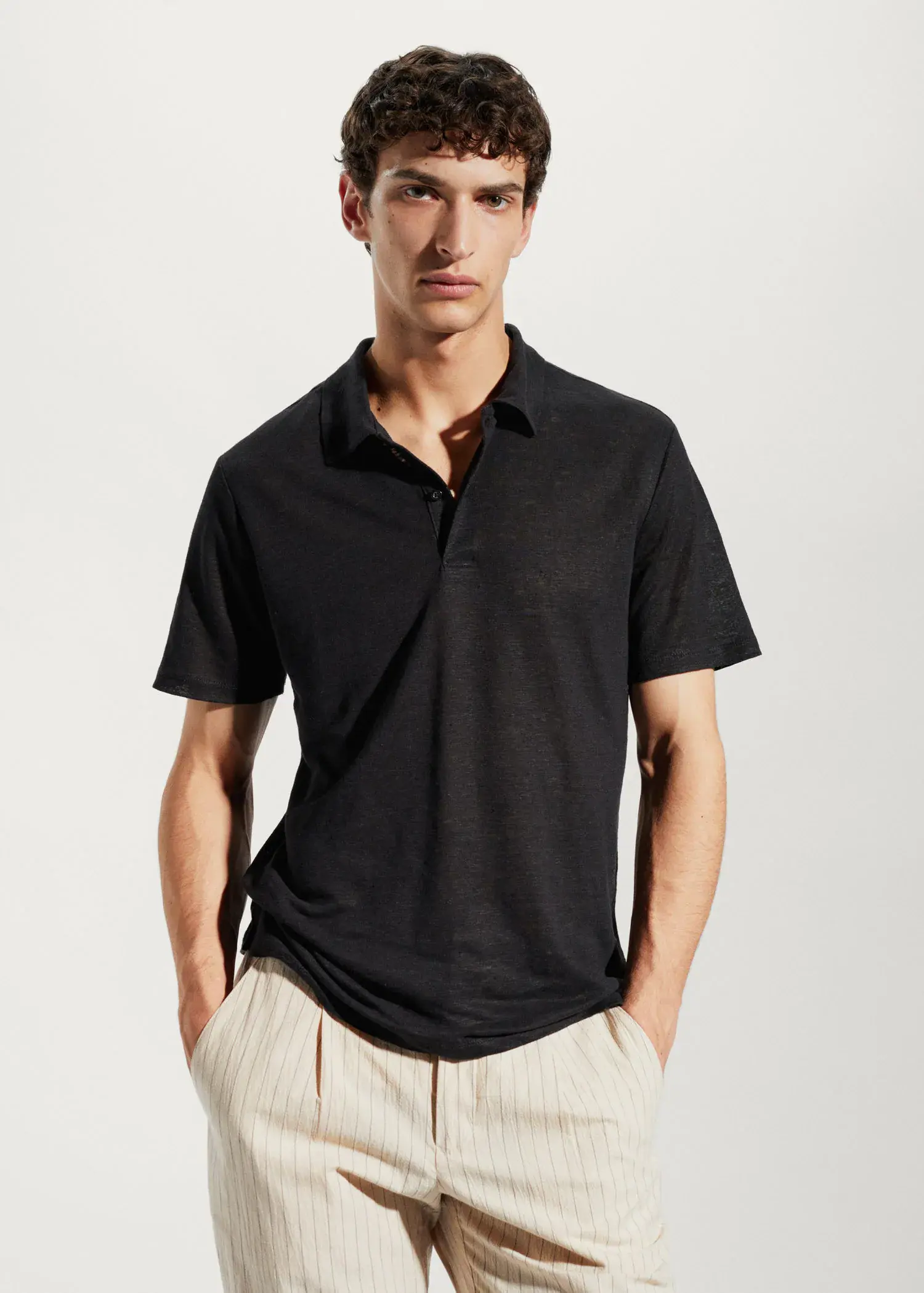 Mango Slim fit 100% linen polo shirt. a man in a black polo shirt is posing for a picture. 