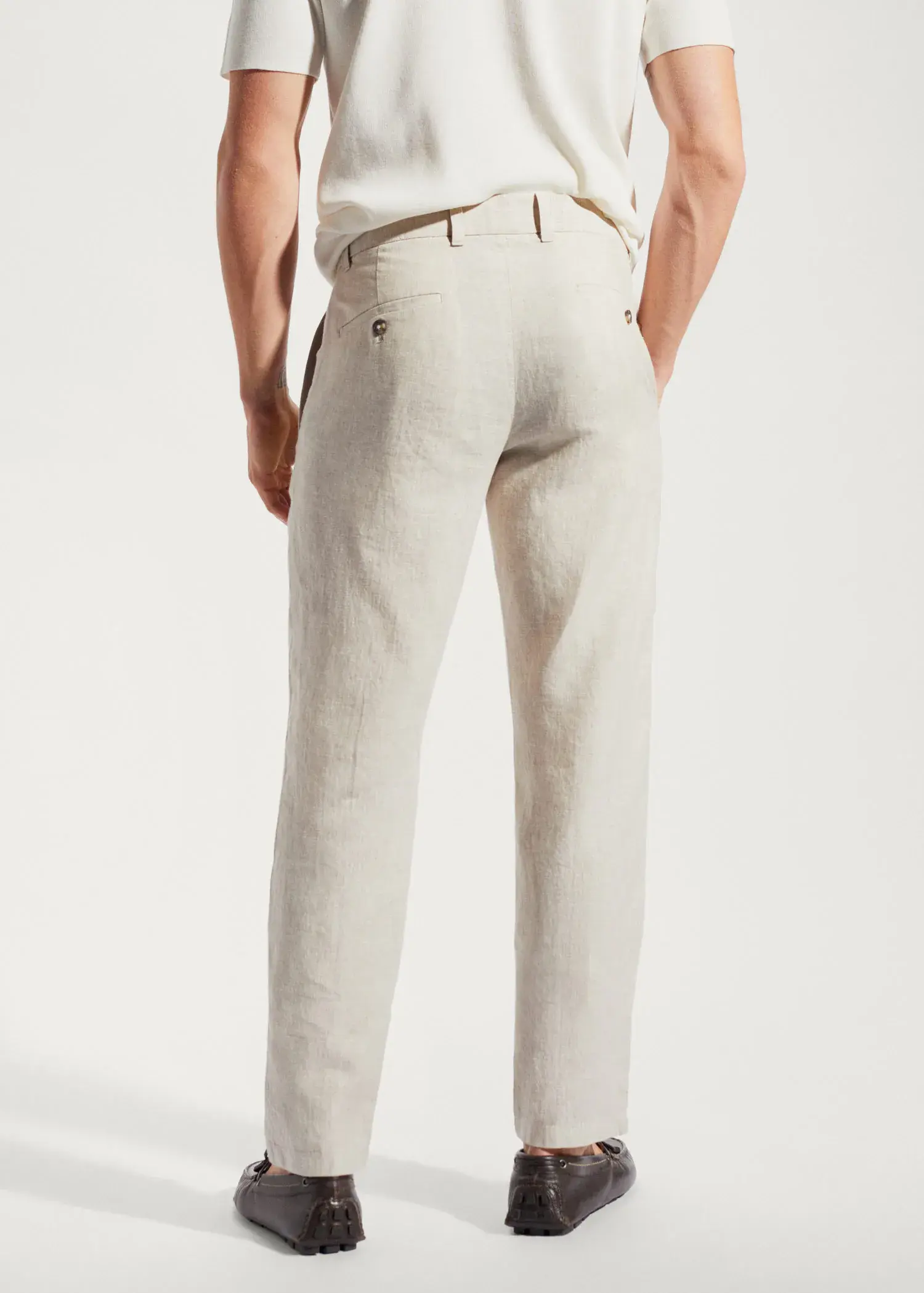 Mango Slim-fit 100% linen trousers. a man wearing a white shirt and beige pants. 
