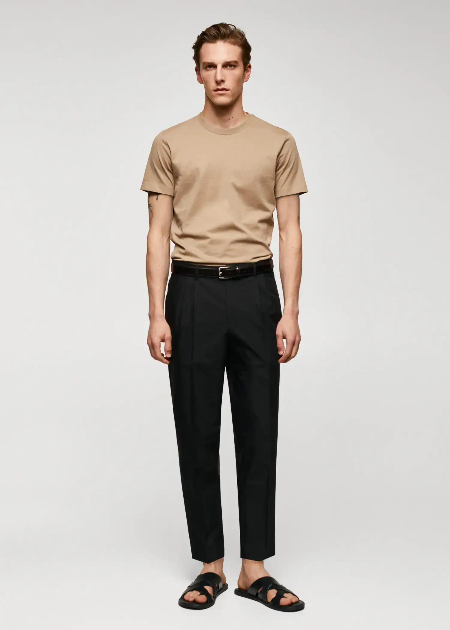 Mango Basic cotton stretch T-shirt. a man in a tan t-shirt and black pants. 