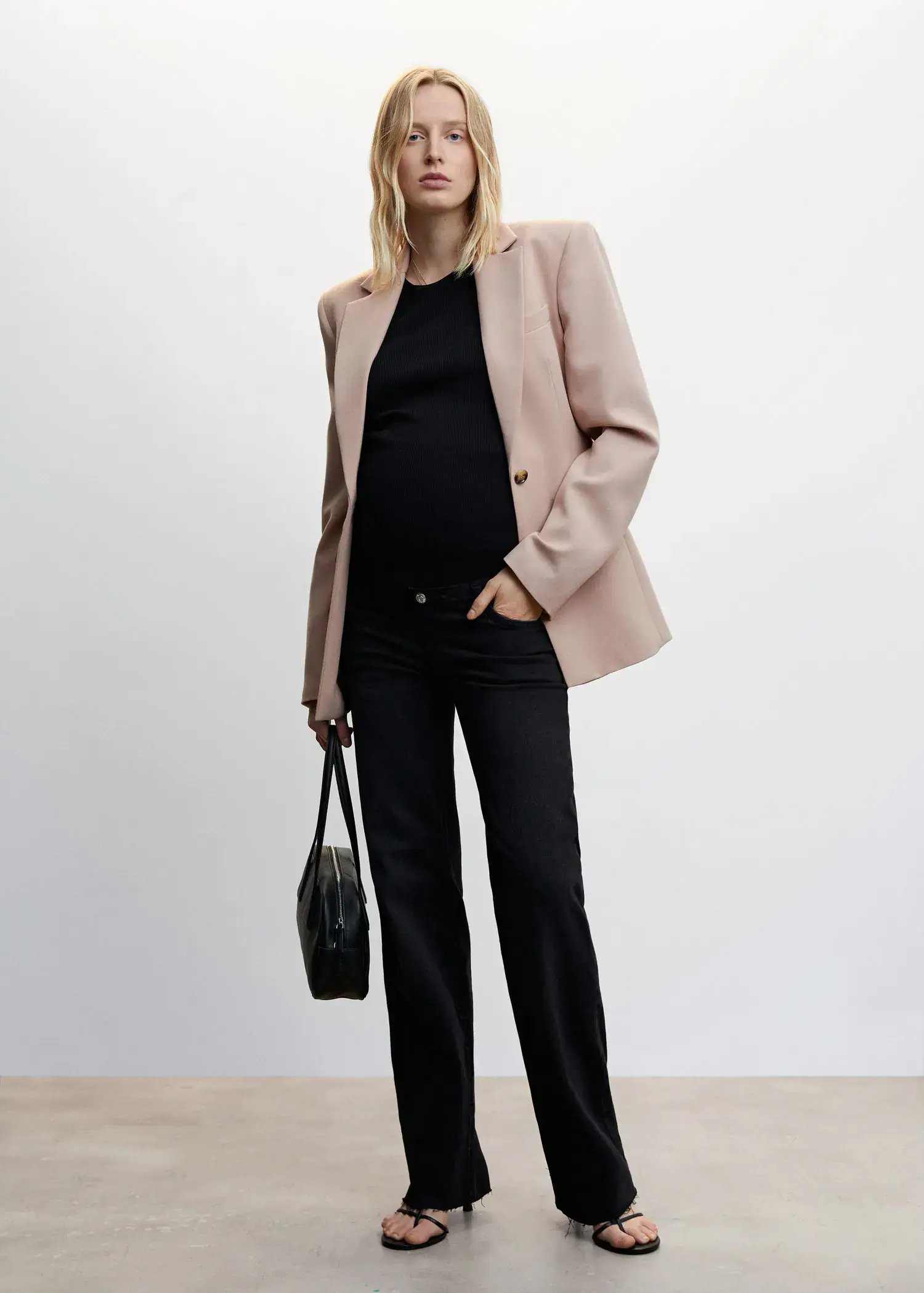 Mango Maternity wideleg jeans. a woman wearing a suit and holding a purse. 