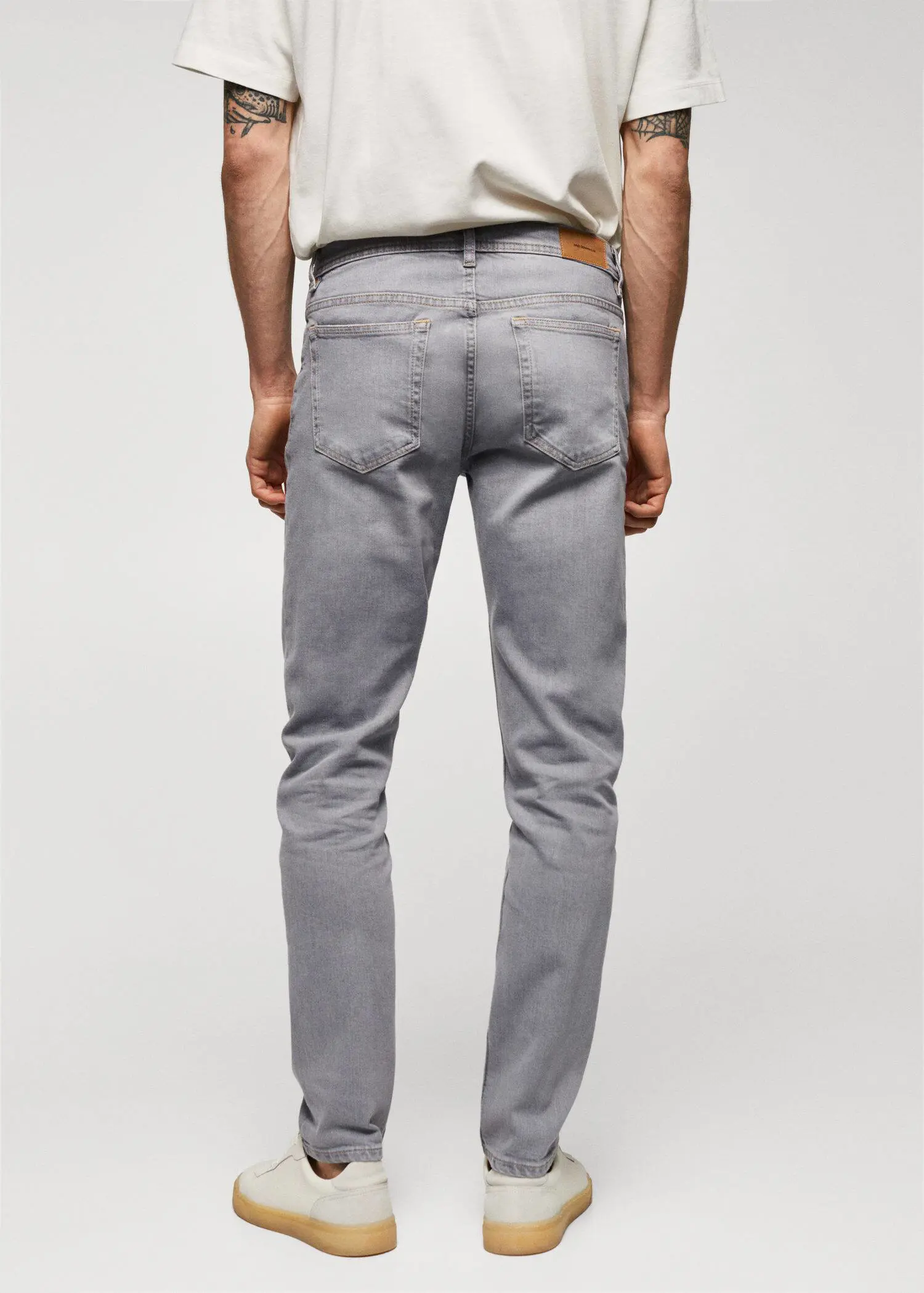 Mango Jan slim-fit jeans. a person wearing grey pants and a white shirt. 