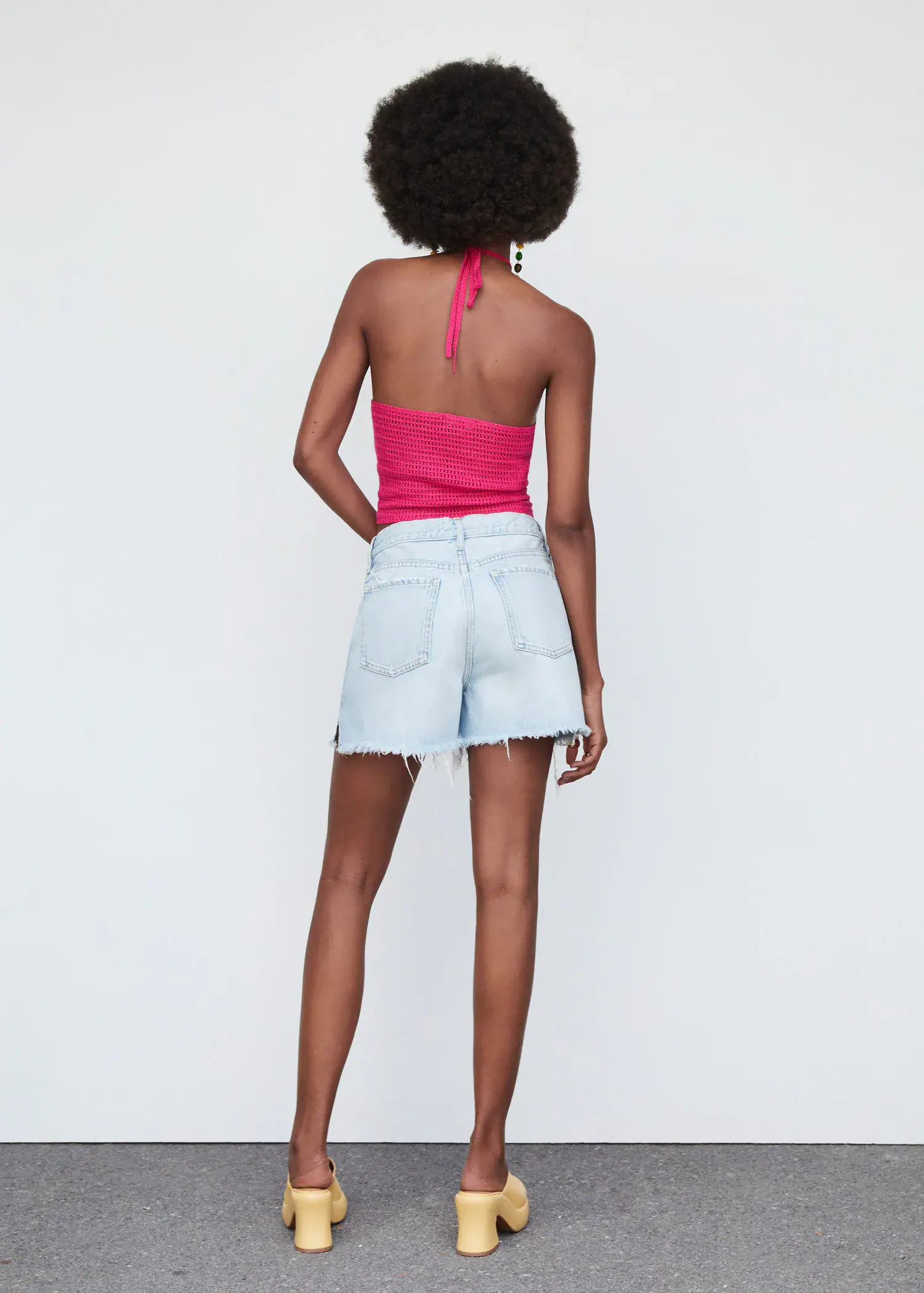 Mango Bow collar top. a woman in a pink top and white shorts. 