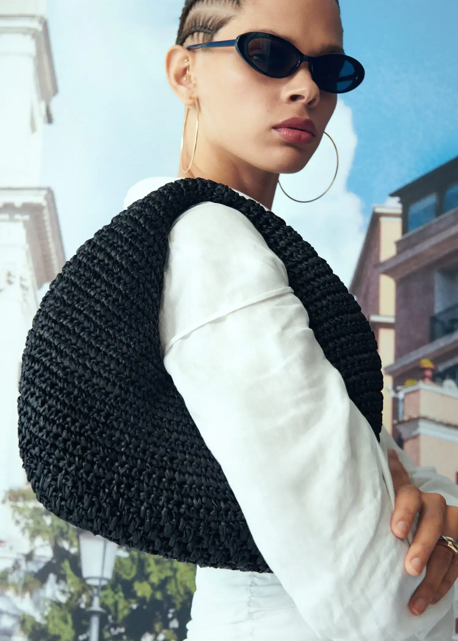 Mango Round natural fiber bag. a close up of a person wearing a black and white outfit 