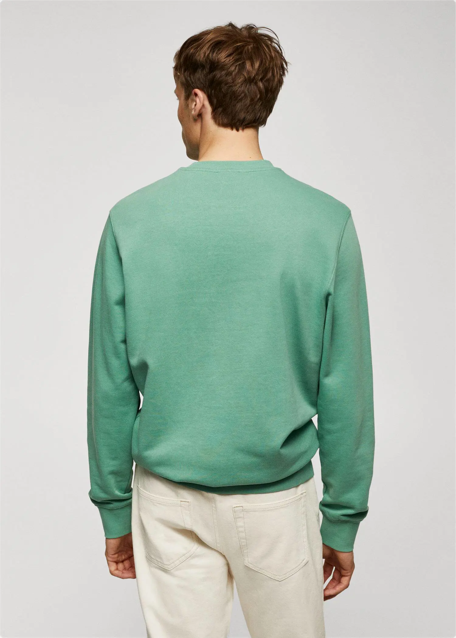 Mango 100% cotton basic sweatshirt . a man wearing a green sweatshirt standing in front of a white wall. 