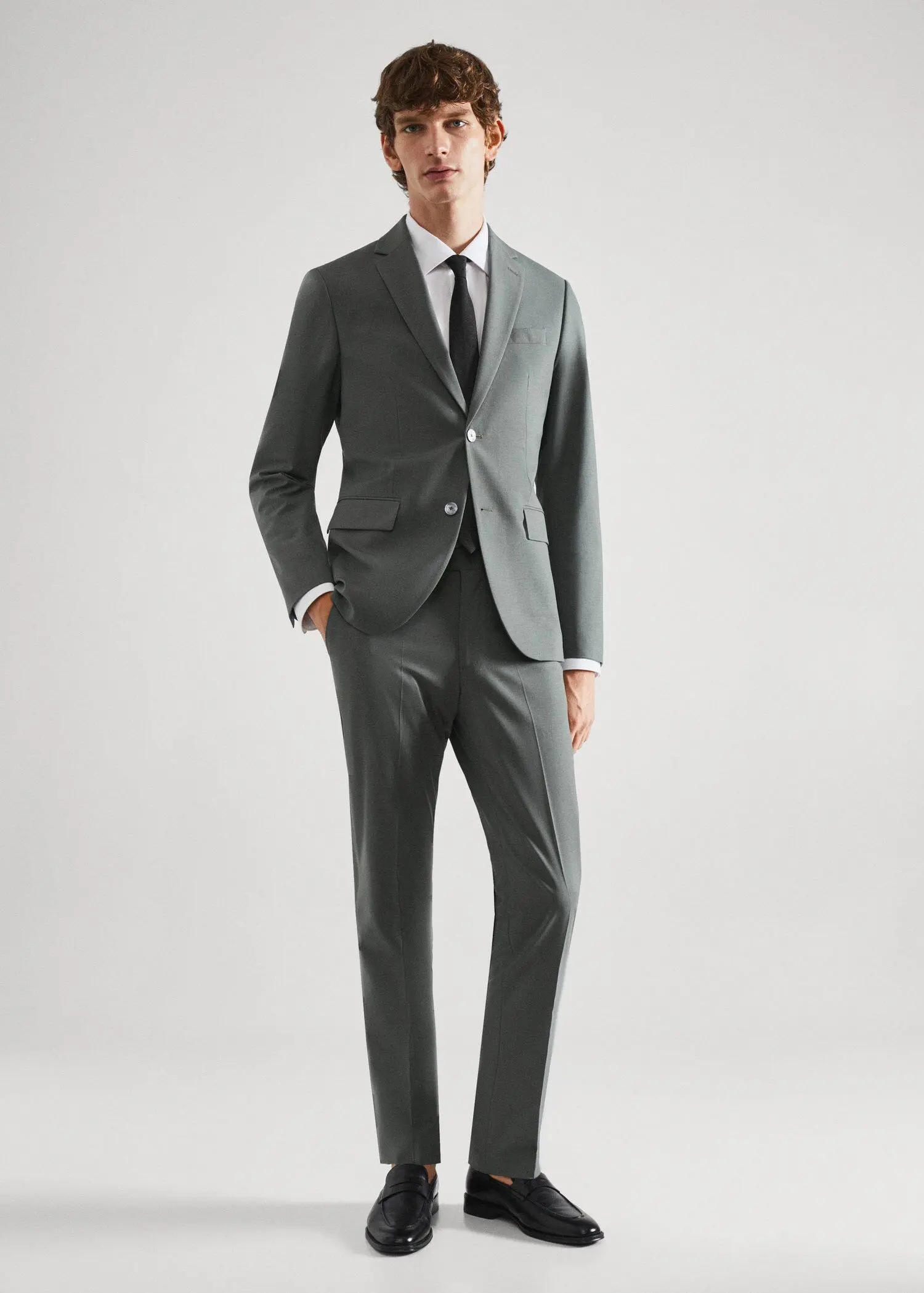 Mango Slim-fit wool suit blazer. a man wearing a suit and tie standing in a room. 