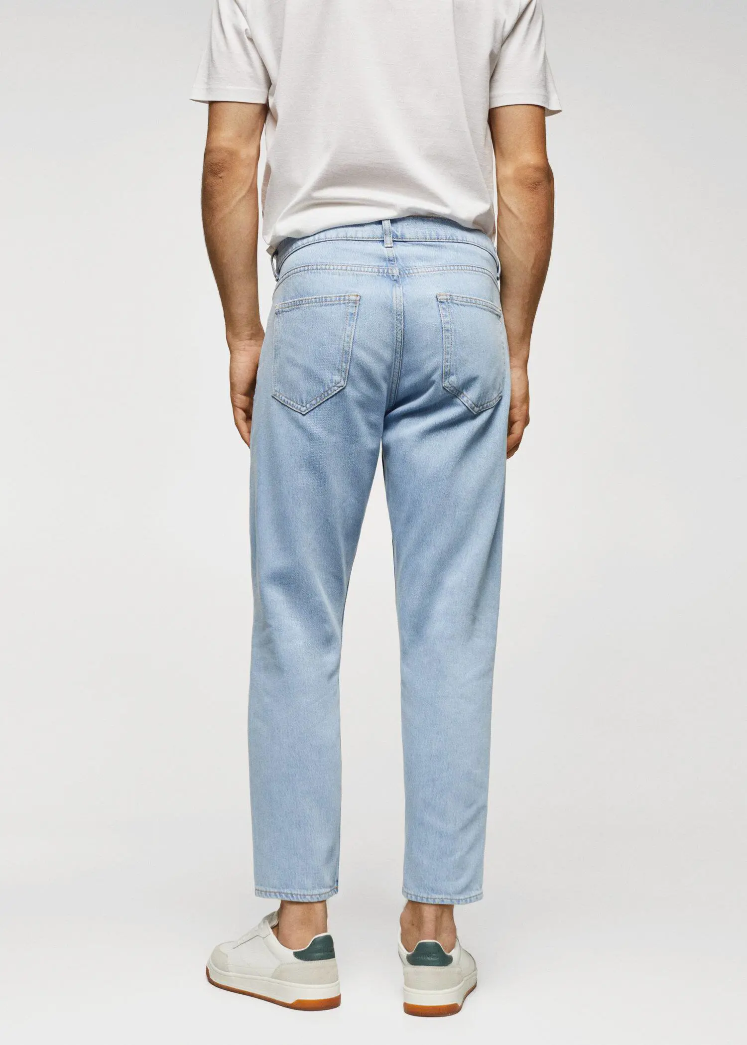 Mango Lightweight light-wash tapered-fit jeans. a person wearing light blue jeans and a white shirt. 