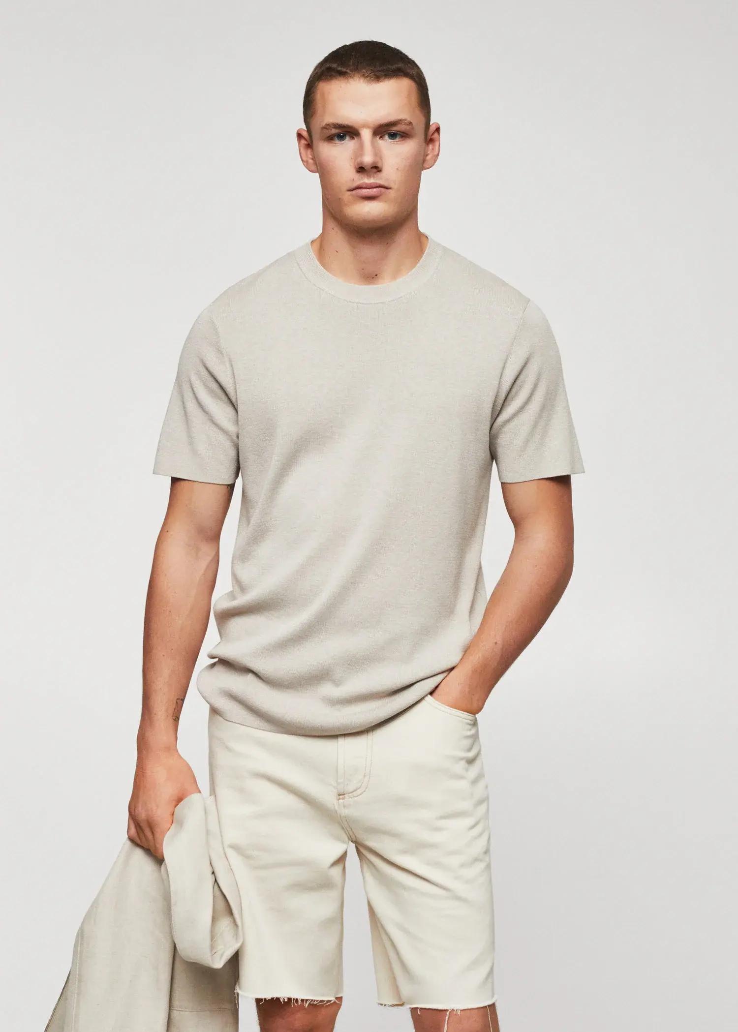 Mango Cotton fine-knit t-shirt. a man wearing a light colored t-shirt and white shorts. 